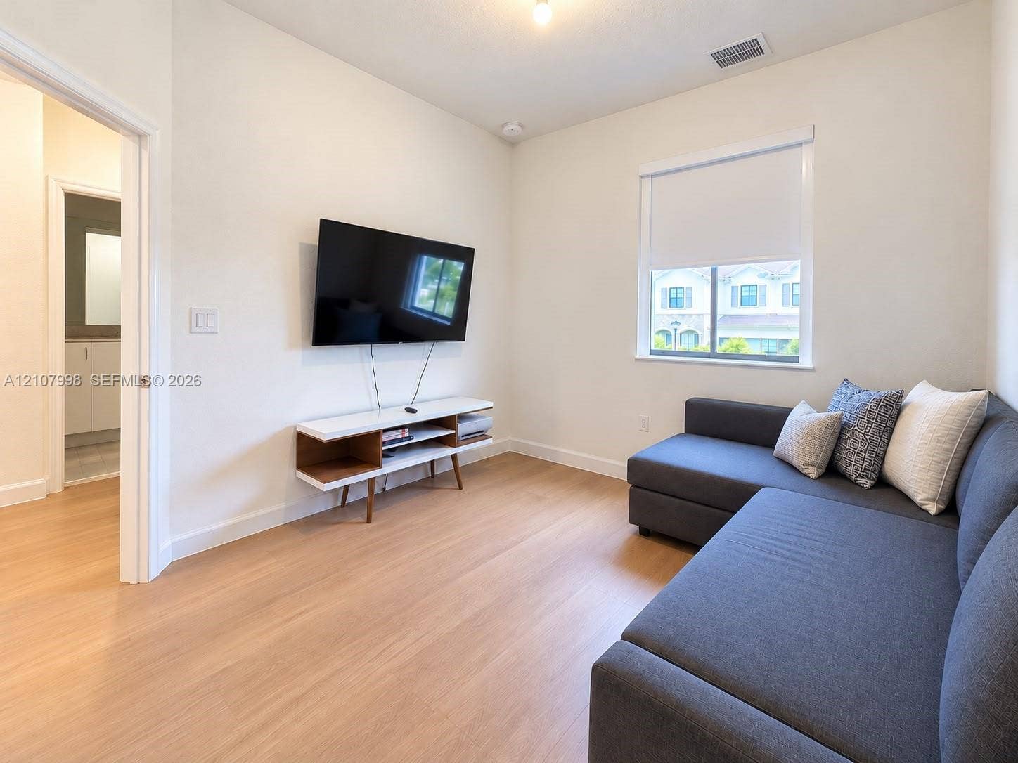 23471 SW 129th Avenue, Homestead, Homestead, FL 33032 Neutral interior featuring wood-finish flooring, crisp white walls, and a single-hung window with a roller shade