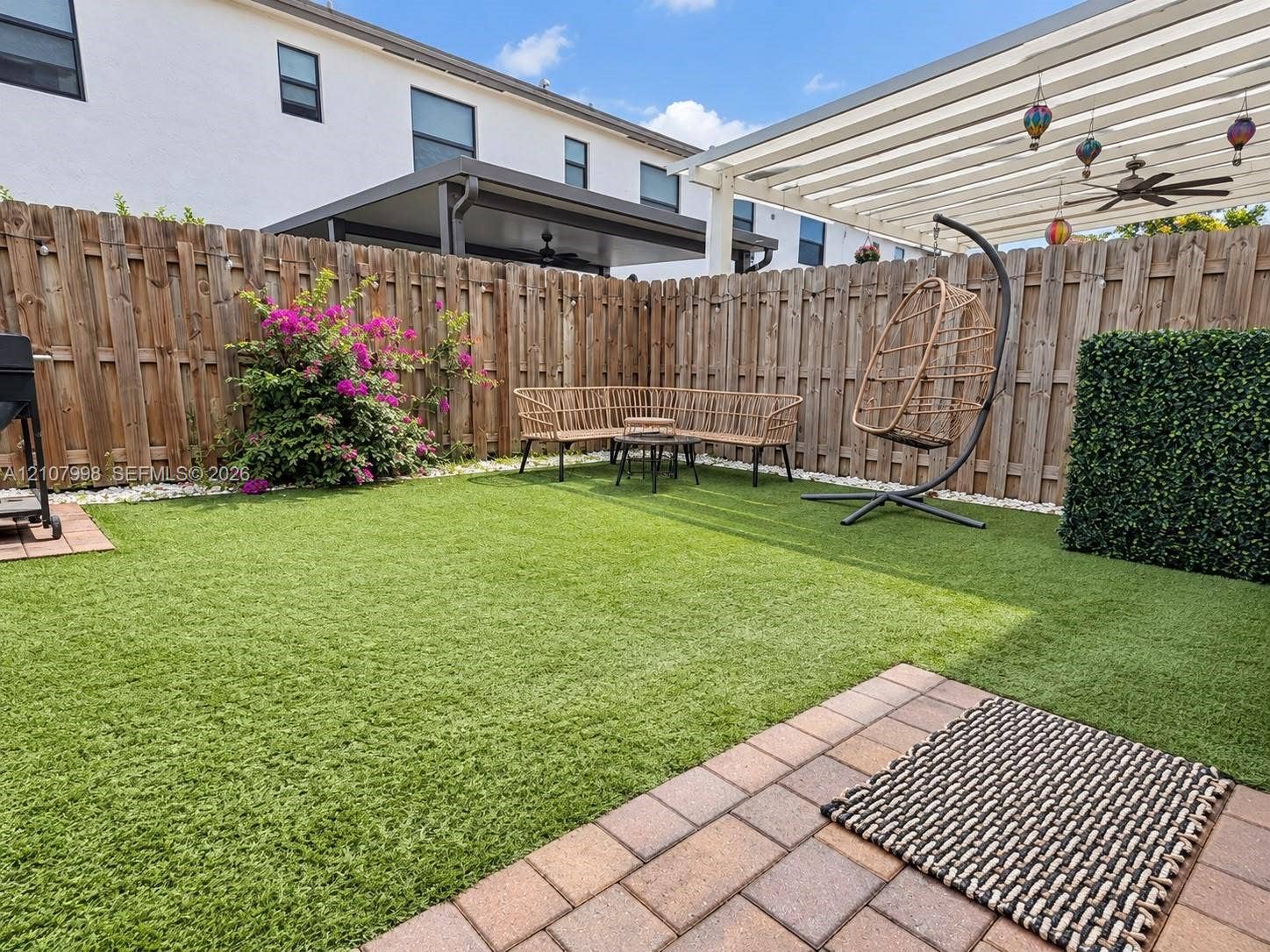 23471 SW 129th Avenue, Homestead, Homestead, FL 33032 Private backyard featuring synthetic turf, paver patio, wood privacy fencing, and an overhead trellis