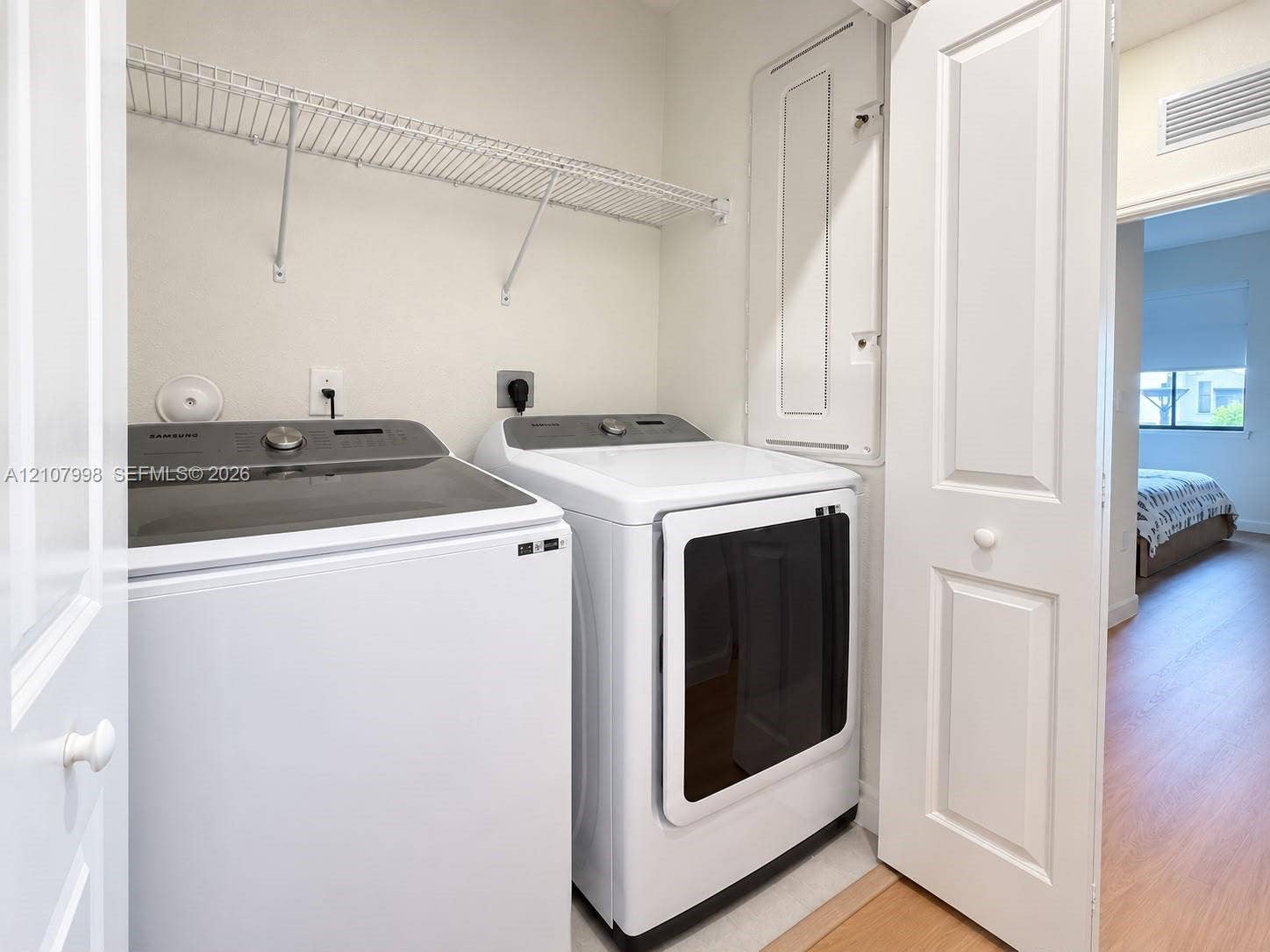23471 SW 129th Avenue, Homestead, Homestead, FL 33032 Laundry area featuring a dedicated closet with white bifold doors, wall-mounted wire shelving, and an integrated electrical panel