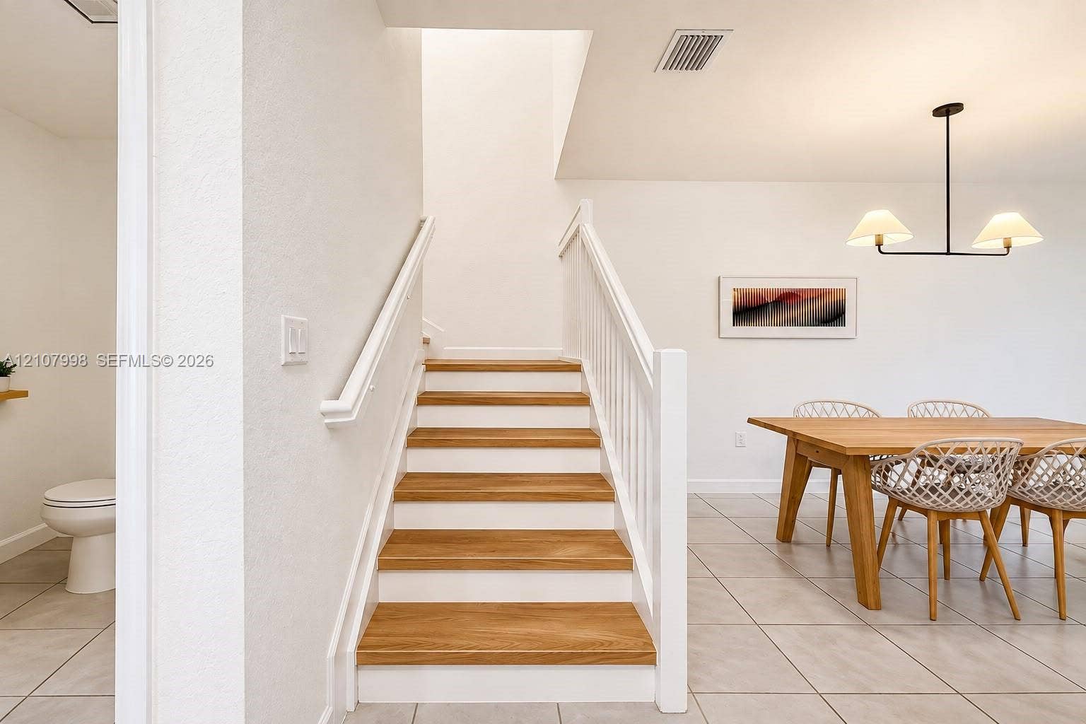23471 SW 129th Avenue, Homestead, Homestead, FL 33032 Staircase featuring wood-finish treads, white risers, and a painted wood balustrade