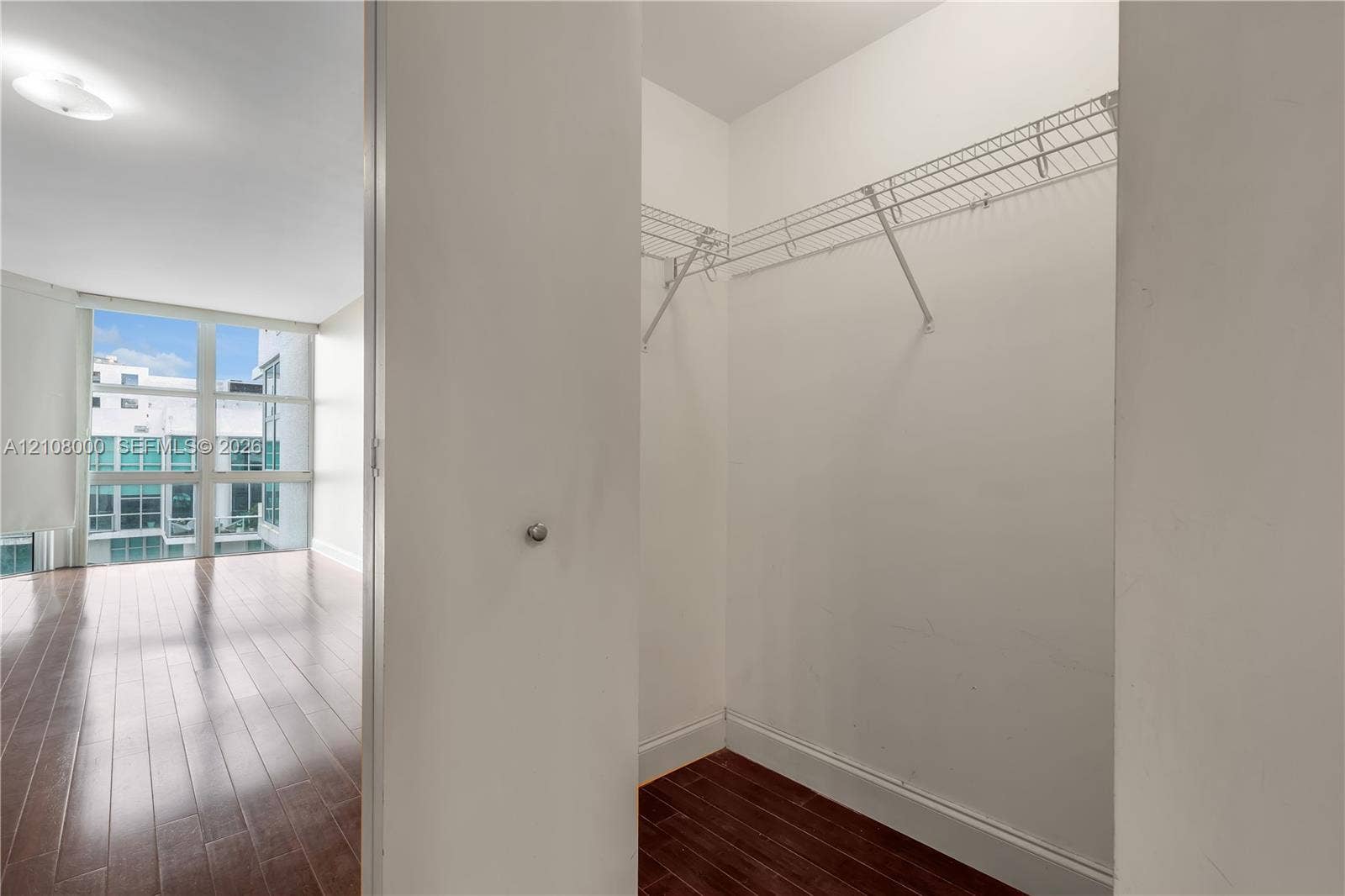 Aventura, FL 33180 Walk-in closet featuring wire shelving, white interior walls, and wood-finish flooring