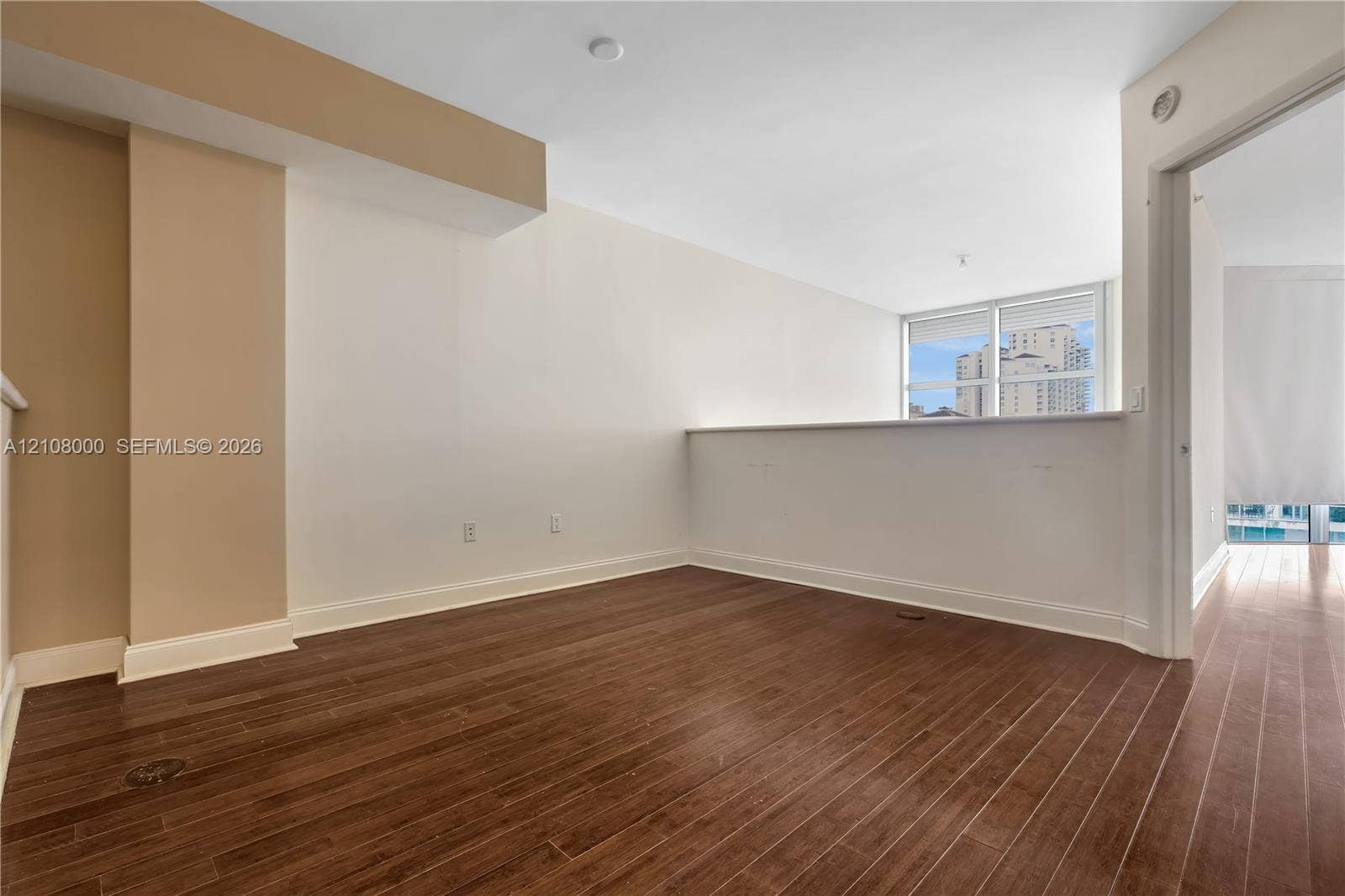 Aventura, FL 33180 Interior space featuring wood-finish flooring, a half-height partition wall, and large windows