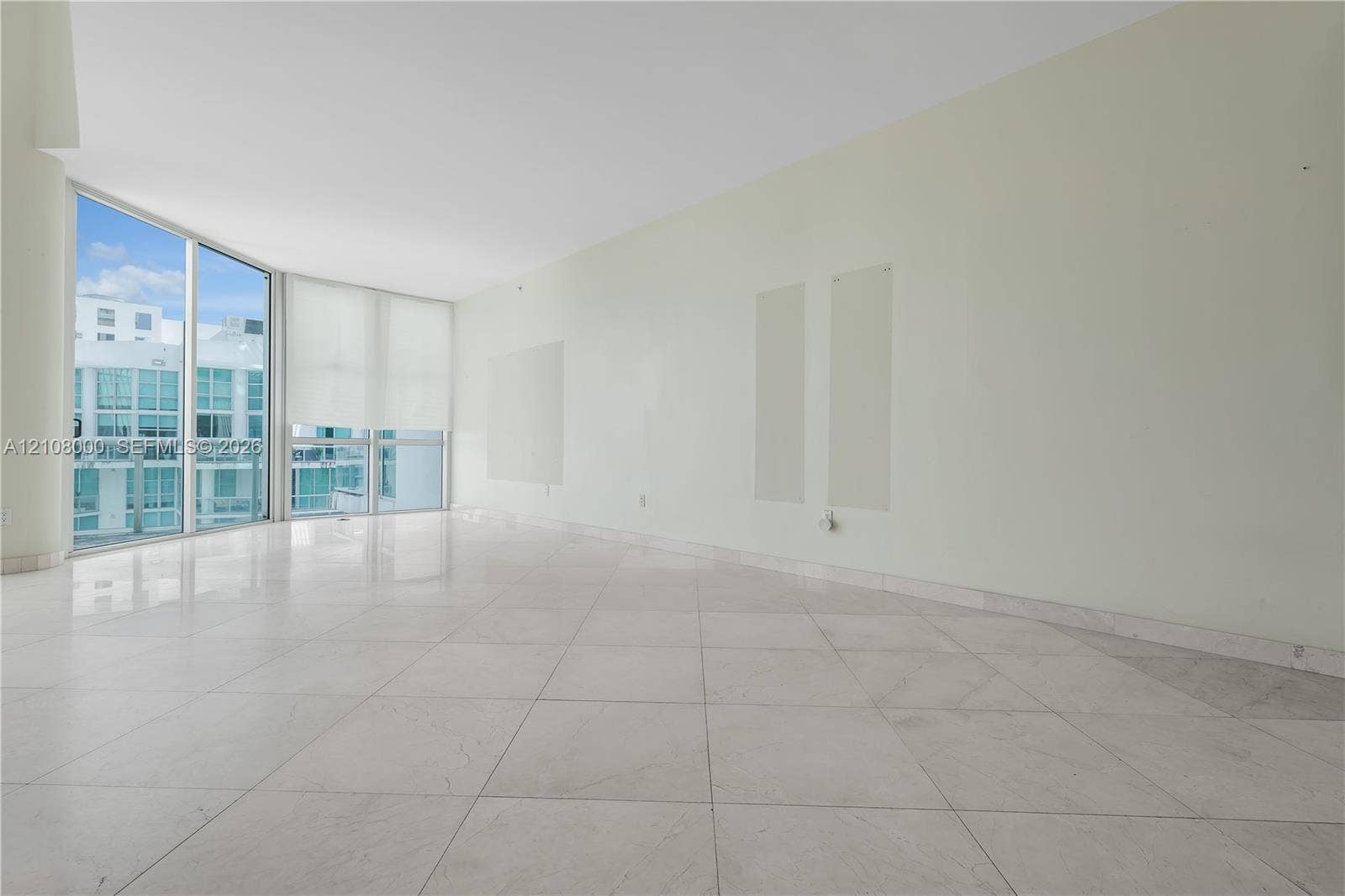 Aventura, FL 33180 Open-concept room featuring floor-to-ceiling glass panels, large-format tile flooring, and a structural concrete column