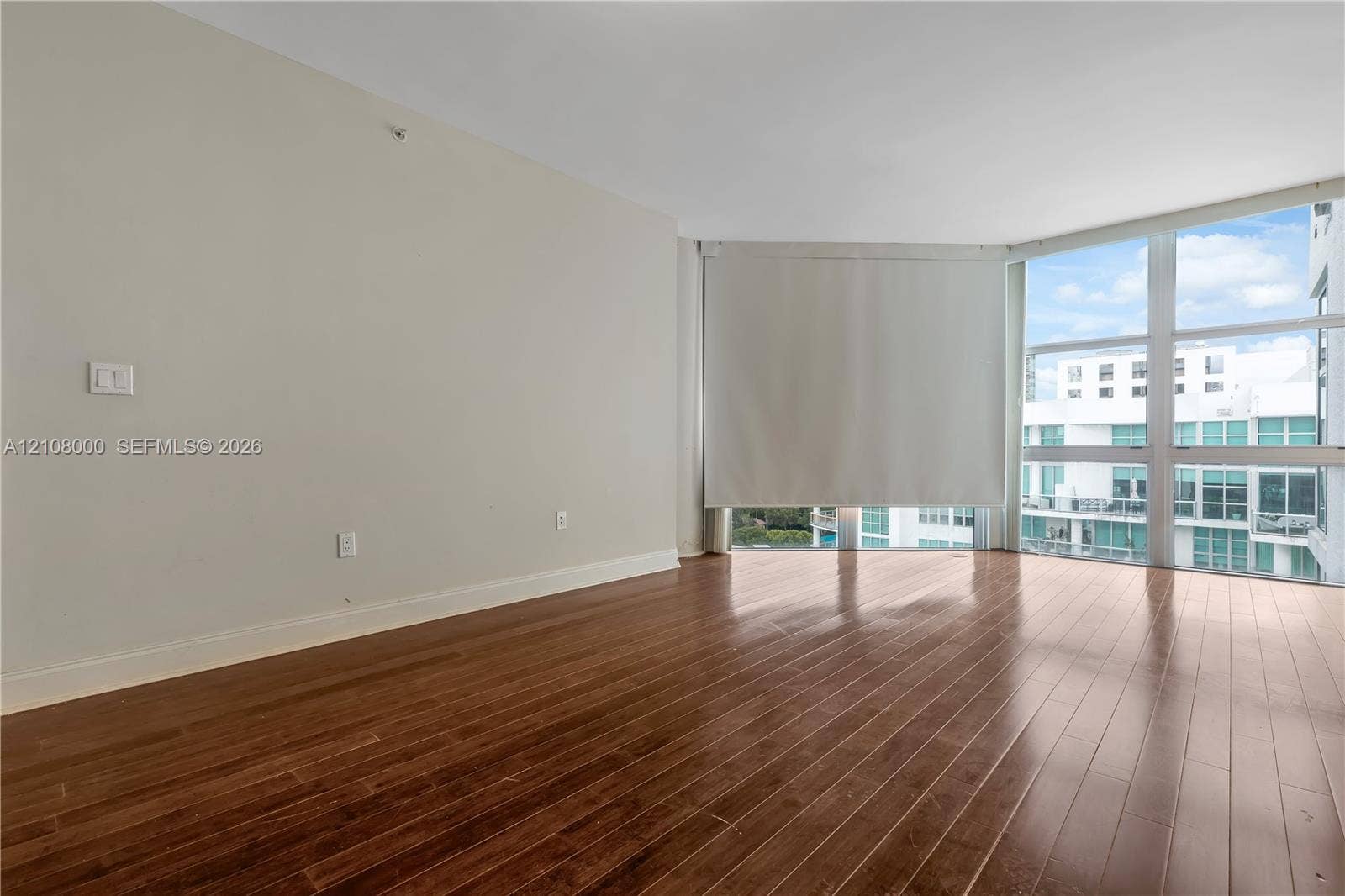 Aventura, FL 33180 Interior space featuring floor-to-ceiling windows, wood-finish flooring, and neutral wall tones