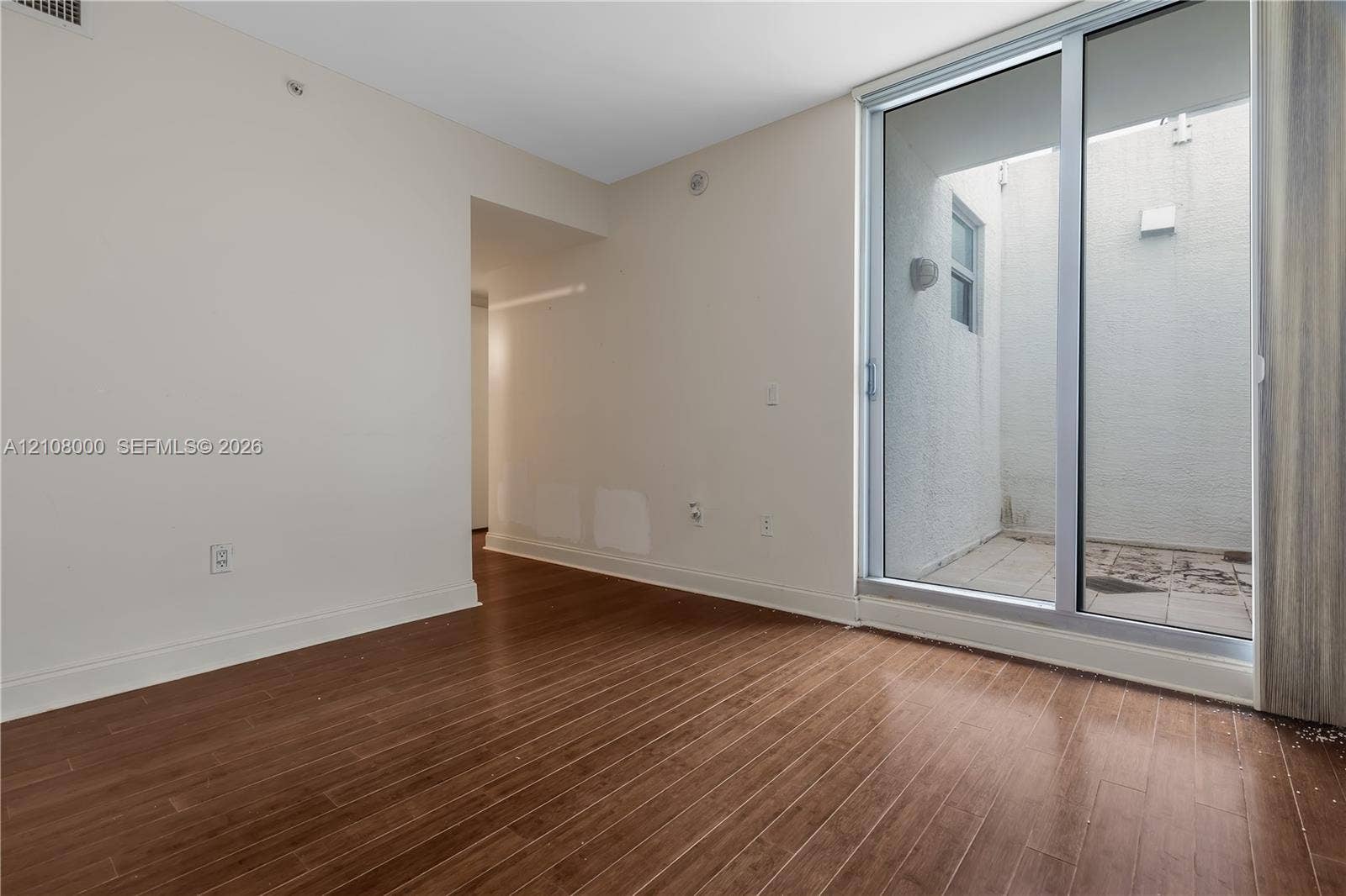 Aventura, FL 33180 Wood-finish flooring, sliding glass door, and private exterior patio space