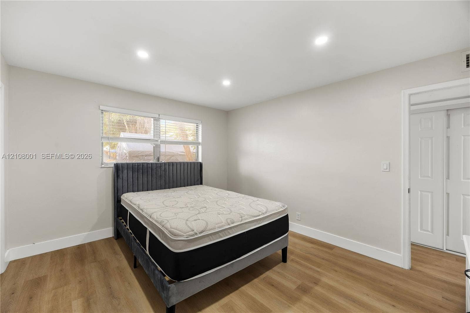 2418 Polk Street, #105, Hollywood, Hollywood, FL 33020 Room featuring wood-finish flooring, recessed lighting, double-pane window with blinds, and a built-in double-door closet