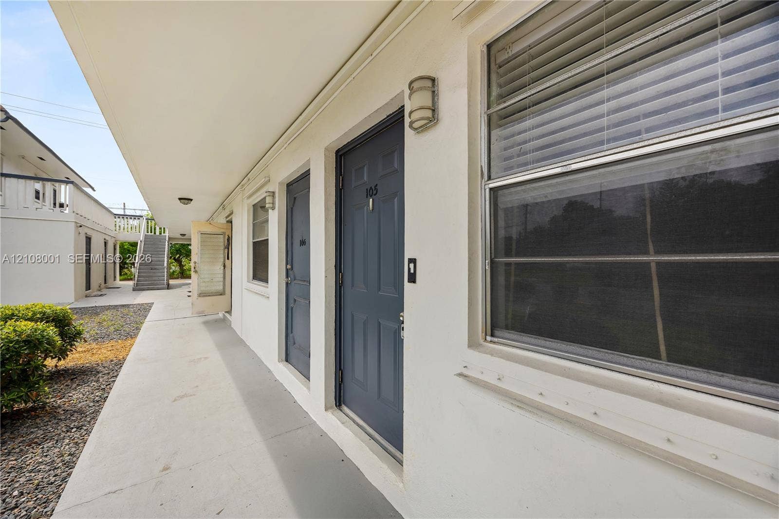 2418 Polk Street, #105, Hollywood, Hollywood, FL 33020 Covered concrete walkway featuring recessed lighting, smooth exterior stucco finish, and paneled entry doors
