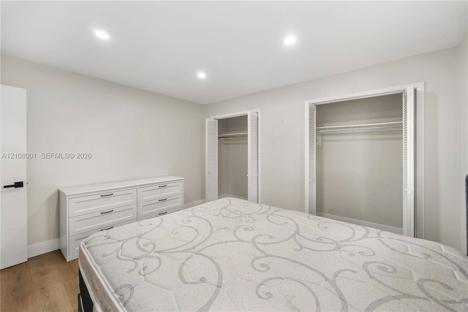 2418 Polk Street, #105, Hollywood, Hollywood, FL 33020 Neutral-toned interior featuring recessed ceiling lighting, wood-finish flooring, and dual closets with bifold louvered doors