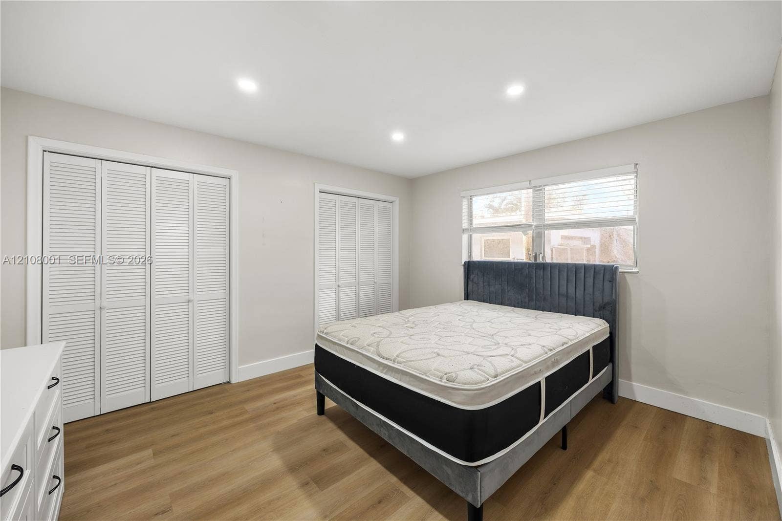 2418 Polk Street, #105, Hollywood, Hollywood, FL 33020 Neutral-toned interior featuring wood-finish flooring, recessed lighting, and two sets of louvered-style closet doors
