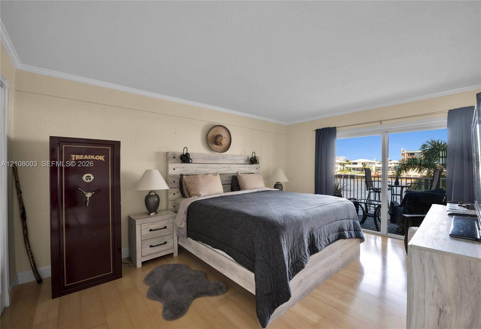 1536 SE 15th Court, #207, Deerfield Beach, FL 33441 Sliding glass doors opening to a waterfront balcony, light-toned wood-finish flooring, and crown molding