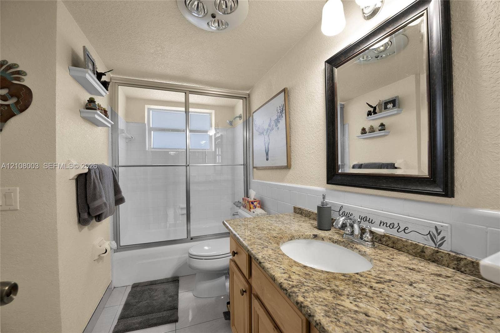 1536 SE 15th Court, #207, Deerfield Beach, FL 33441 Bathroom featuring a vanity with a stone-finish countertop, undermount oval sink, chrome dual-handle faucet, and built-in wood-finish cabinetry