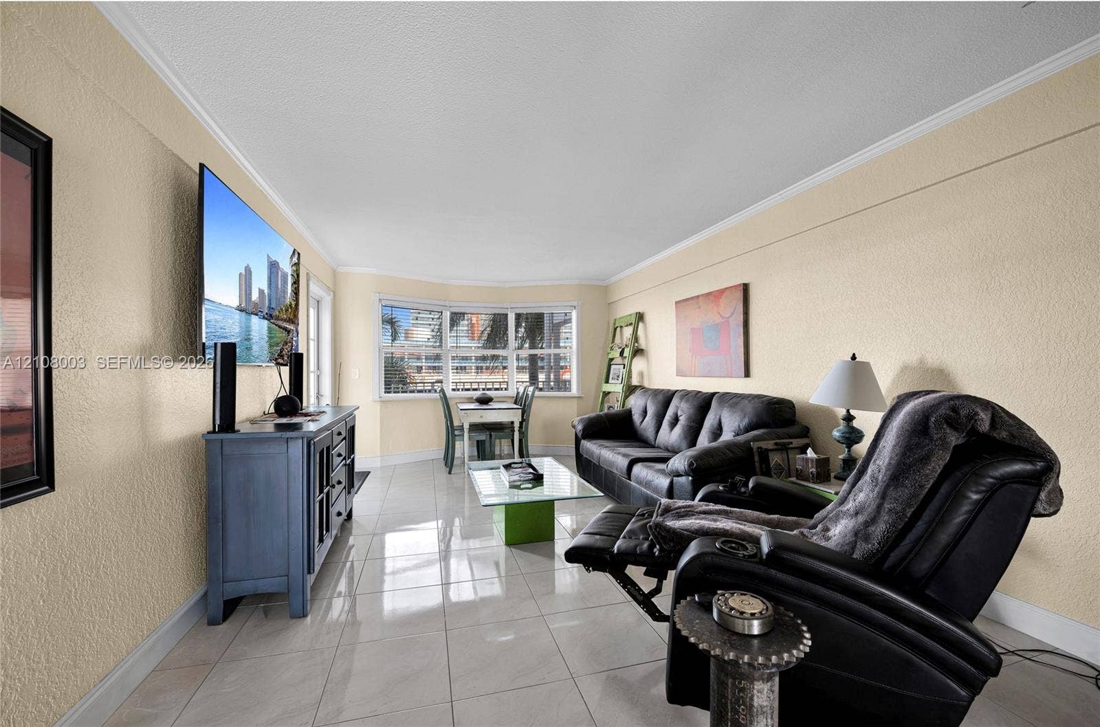 1536 SE 15th Court, #207, Deerfield Beach, FL 33441 Living area featuring light-colored tile flooring, textured wall finishes, and a bay window