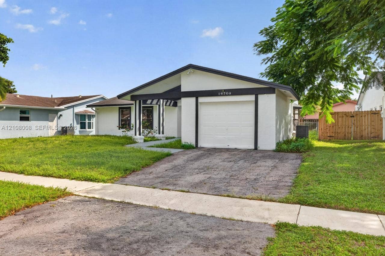 16708 SW 5th Way, Weston, Weston, FL 33326 Single-story exterior featuring a low-slope roofline, attached one-car garage, white facade, and a concrete walkway