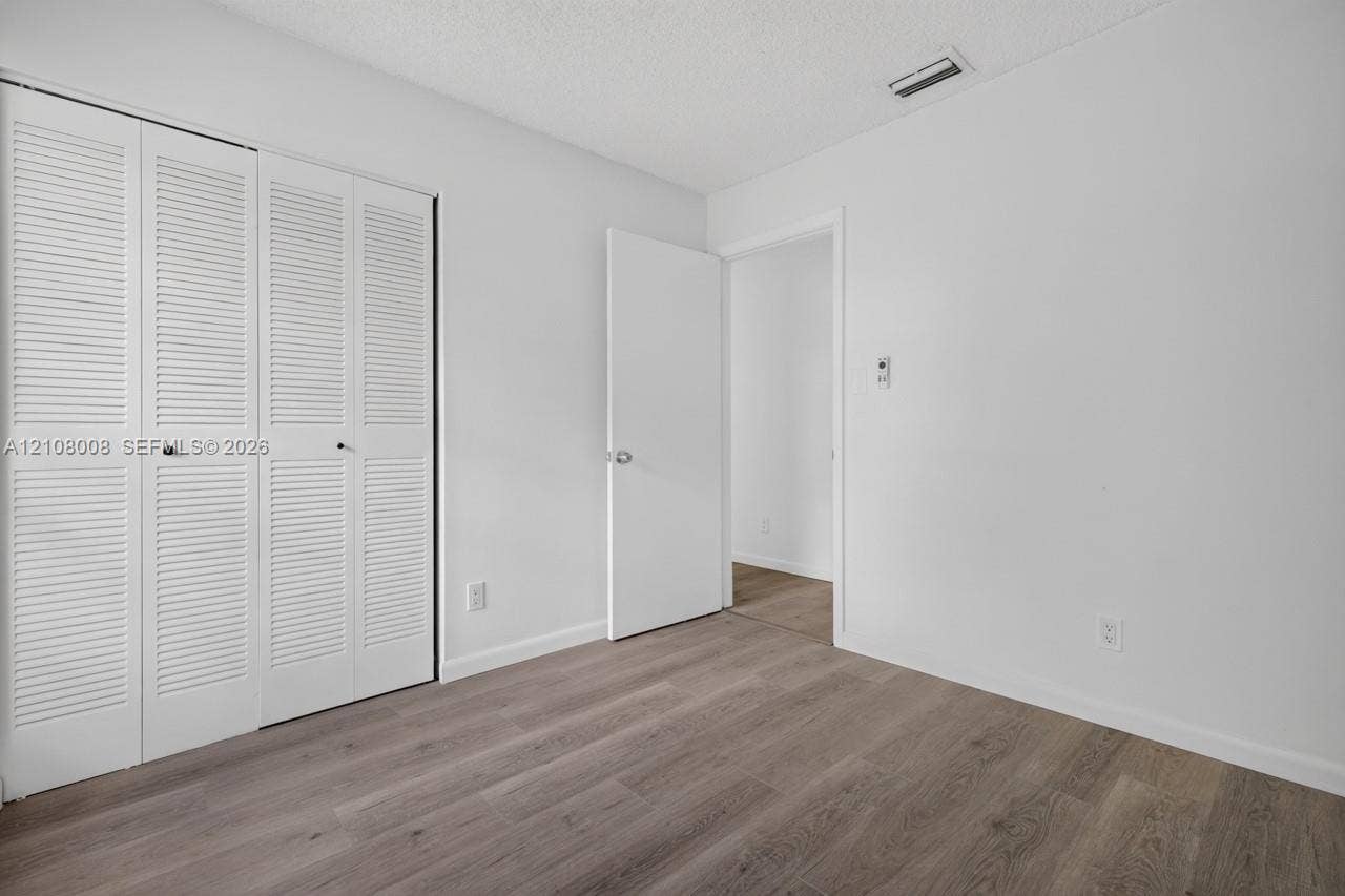16708 SW 5th Way, Weston, Weston, FL 33326 Interior space featuring wood-finish flooring, white walls, and a white louvered closet door