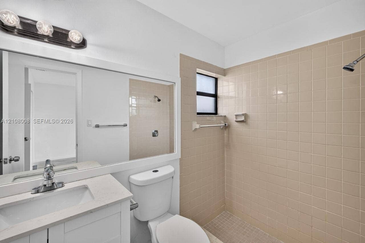 16708 SW 5th Way, Weston, Weston, FL 33326 Bathroom featuring a vanity with a solid-surface countertop, rectangular integrated sink, chrome-finish faucet, wall-spanning mirror, and a tiled shower enclosure