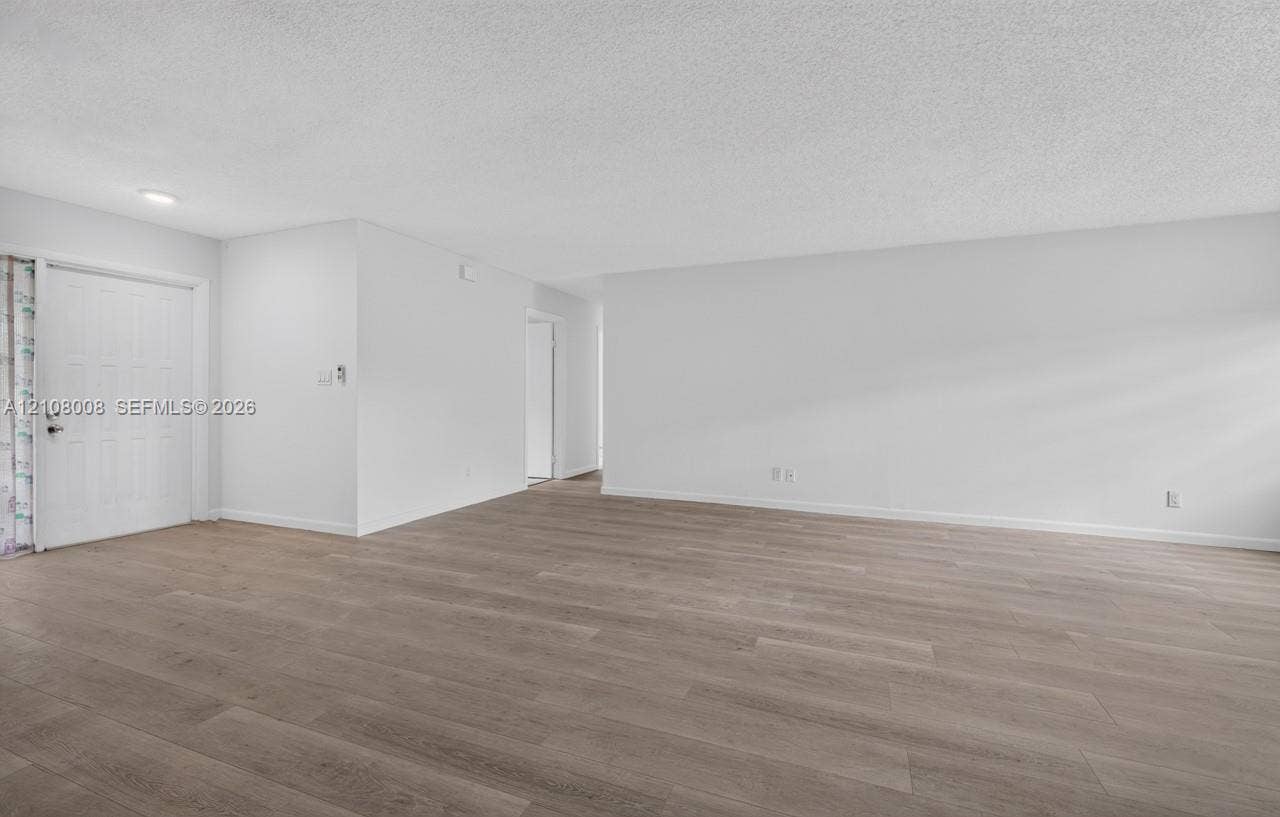 16708 SW 5th Way, Weston, Weston, FL 33326 Open-concept interior featuring light wood-finish flooring, neutral wall tones, and an entry door with a six-panel design