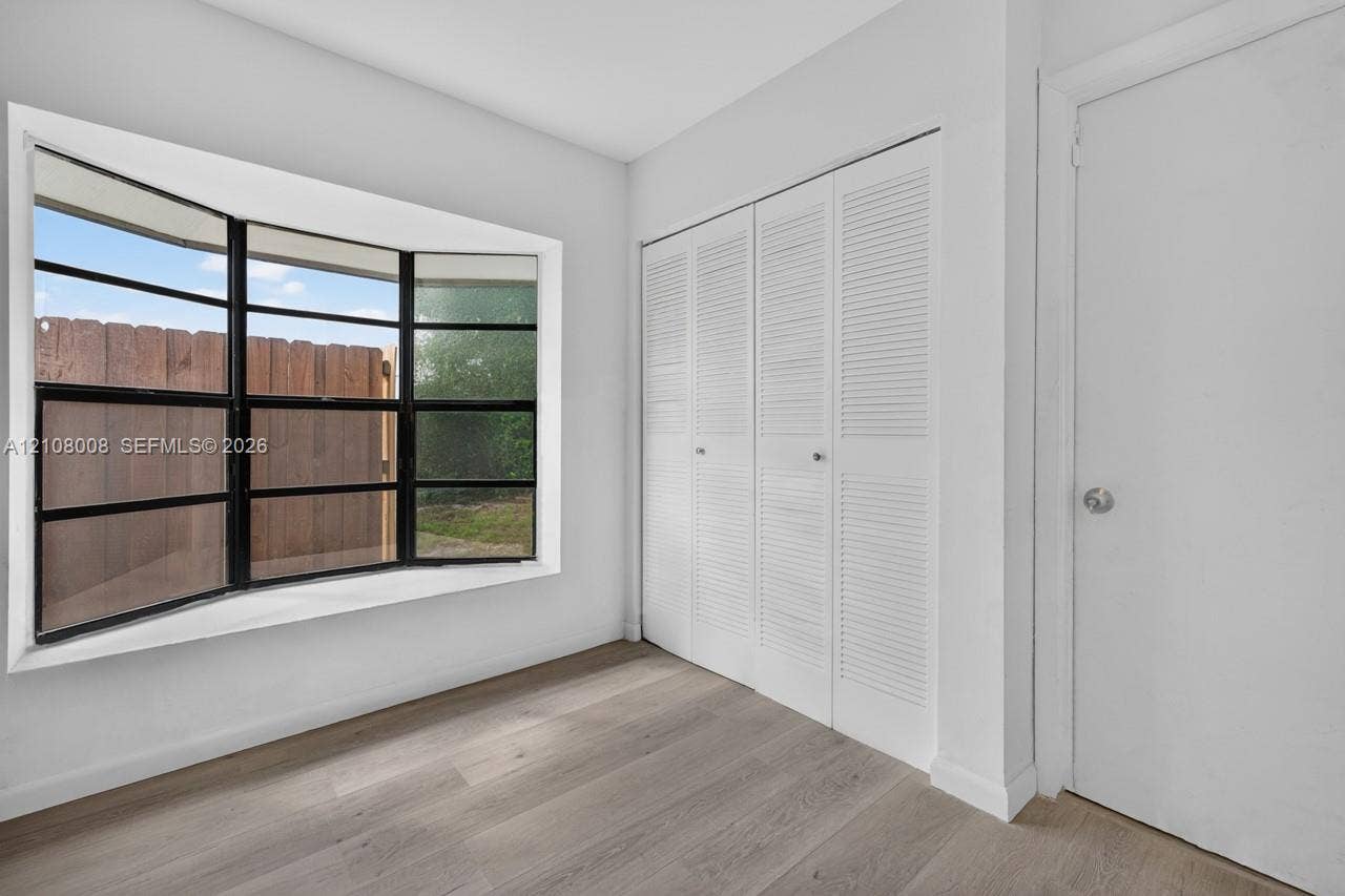 16708 SW 5th Way, Weston, Weston, FL 33326 Multi-panel bay window with black framing, wood-finish flooring, and built-in closet with louvered doors
