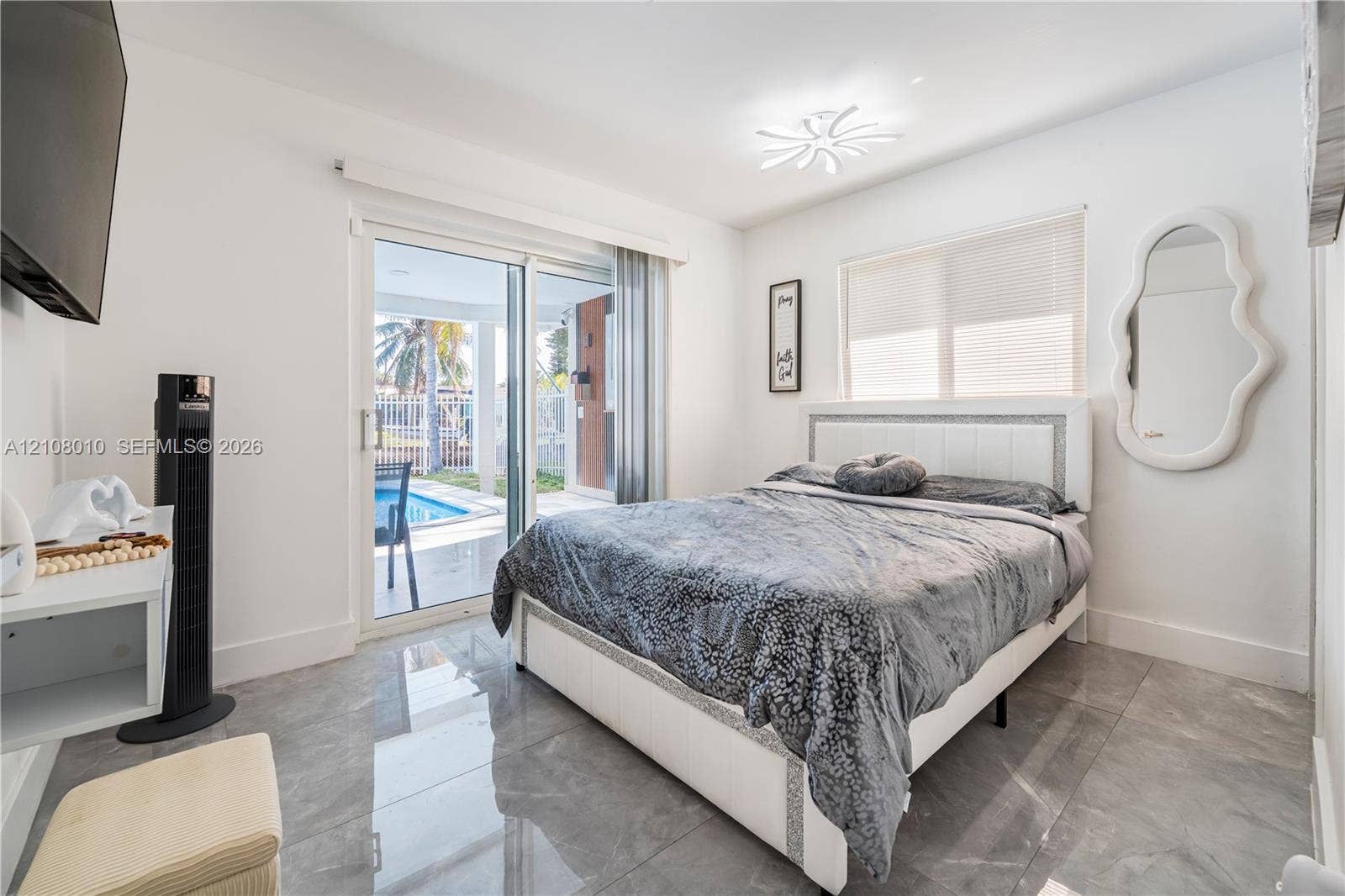 Large-format tile flooring, glass sliding door, and contemporary multi-arm flush mount light fixture