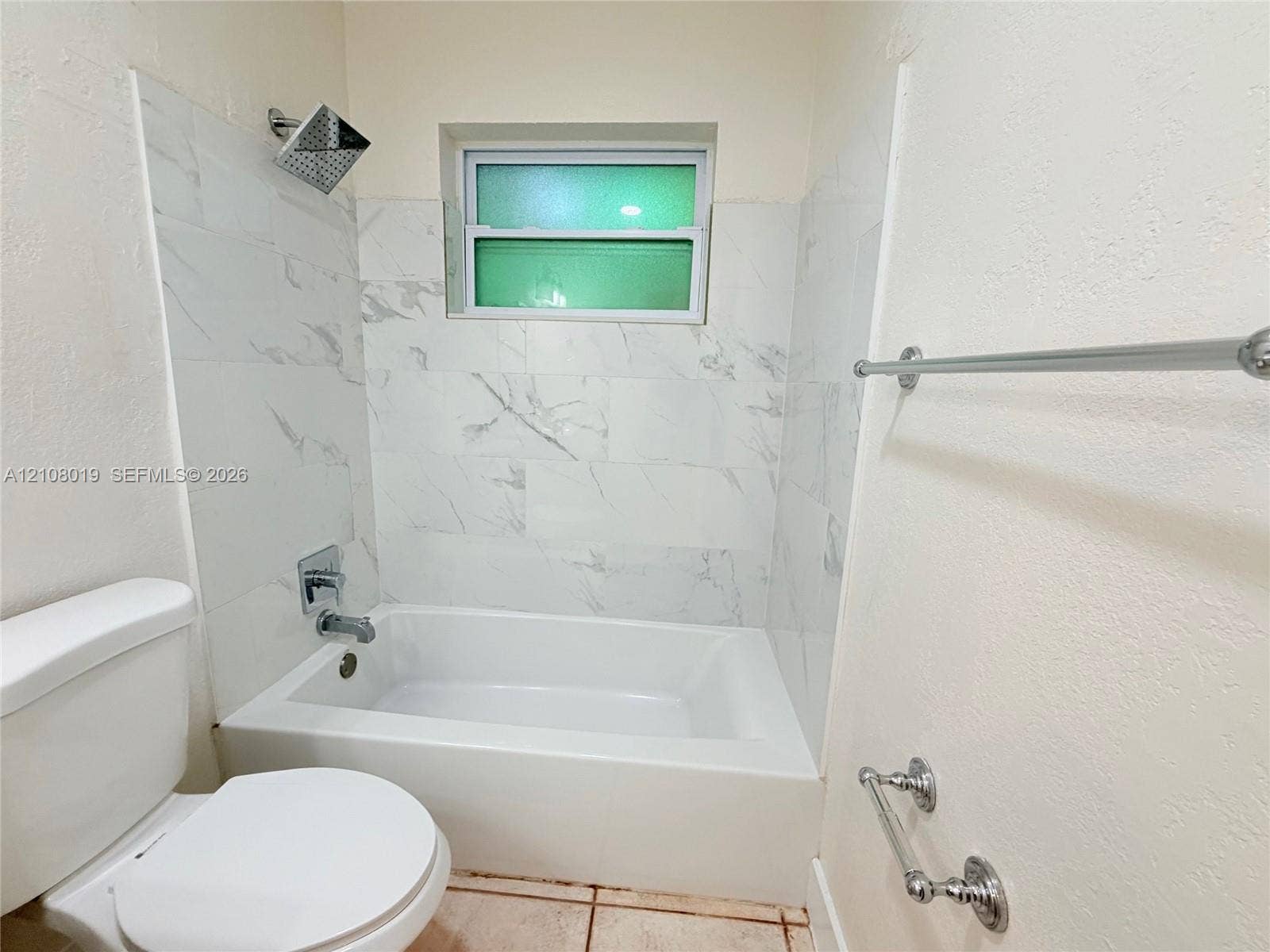 1105 NE 5th Terrace, #1-4, Fort Lauderdale, Fort Lauderdale, FL 33304 Bathtub surround featuring large-format light-toned tile, polished chrome rainfall shower head, integrated wall-mounted faucet, and polished chrome towel hardware