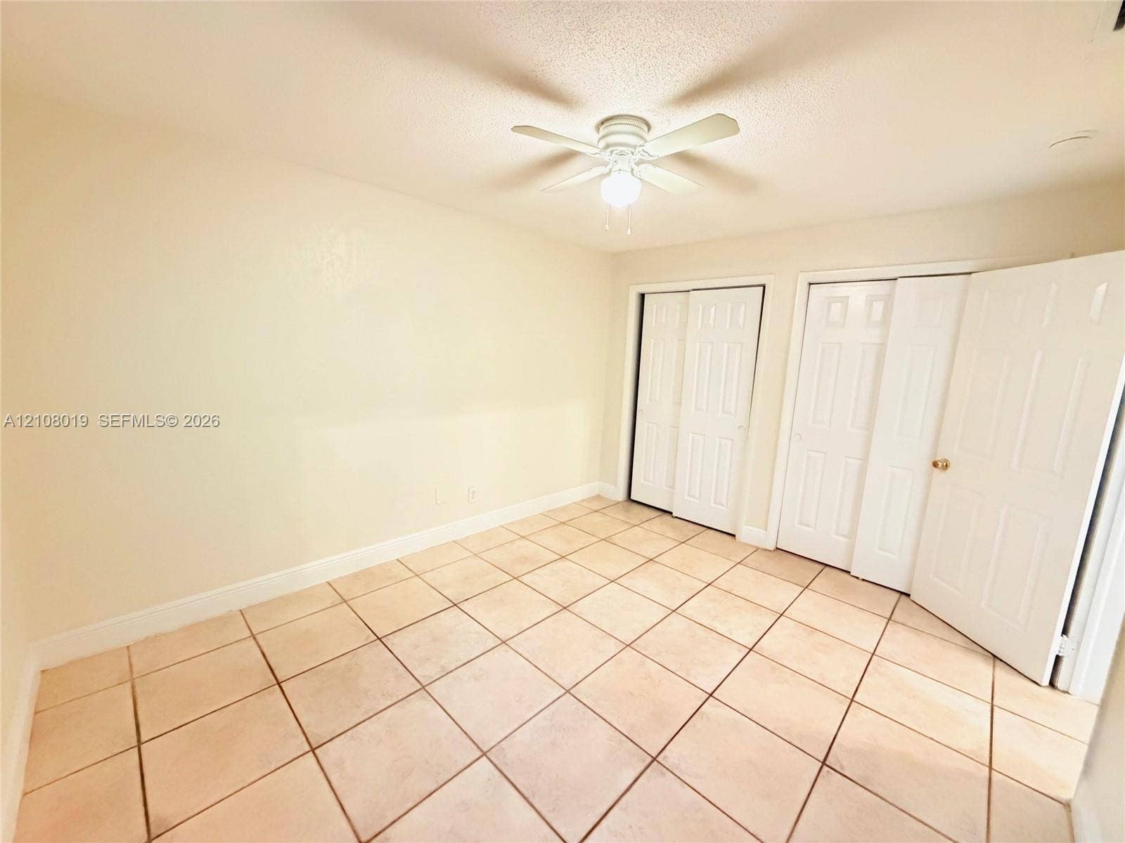 1105 NE 5th Terrace, #1-4, Fort Lauderdale, Fort Lauderdale, FL 33304 Neutral-toned ceramic tile flooring, dual sets of white closet doors, and a ceiling fan with integrated lighting