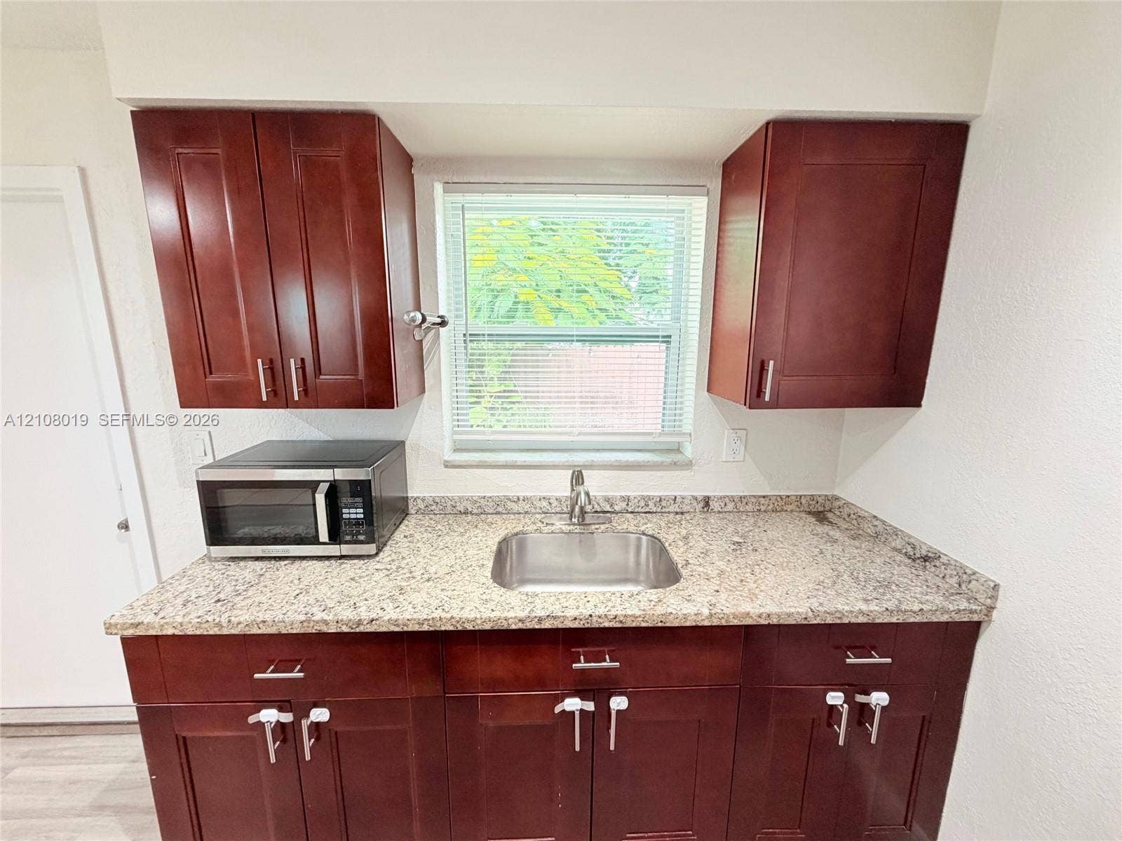 1105 NE 5th Terrace, #1-4, Fort Lauderdale, Fort Lauderdale, FL 33304 Kitchen featuring dark wood-finish cabinetry, stone-finish countertops, stainless steel undermount sink, and a high-arch faucet