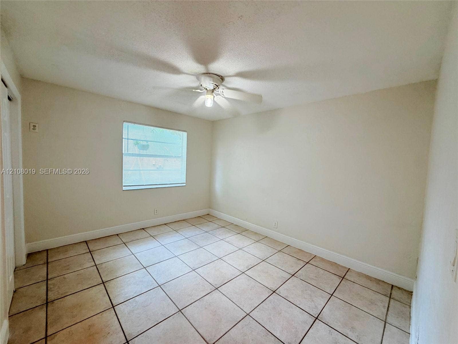 1105 NE 5th Terrace, #1-4, Fort Lauderdale, Fort Lauderdale, FL 33304 Neutral-toned room featuring tiled flooring, a single window, and a ceiling fan with integrated lighting