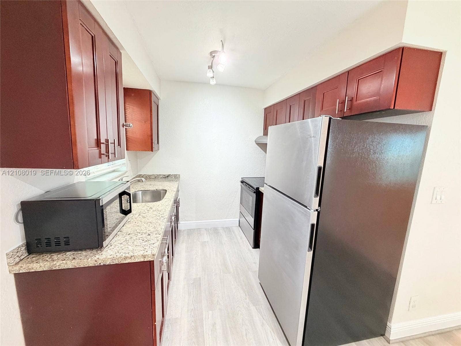 1105 NE 5th Terrace, #1-4, Fort Lauderdale, Fort Lauderdale, FL 33304 Kitchen featuring wood-finish cabinetry, stone-surface countertops, stainless steel refrigerator, integrated range, and recessed ceiling lighting
