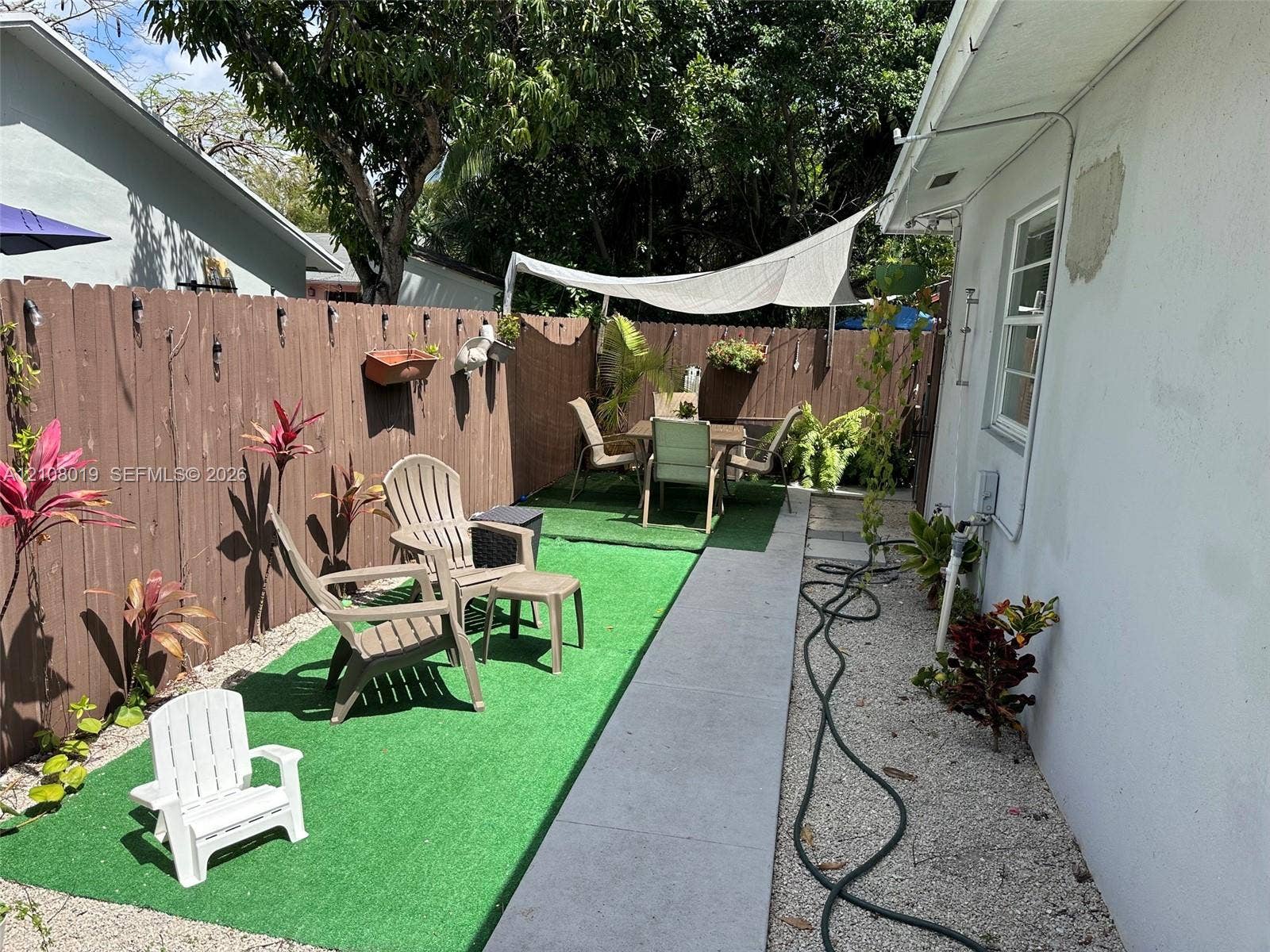 1105 NE 5th Terrace, #1-4, Fort Lauderdale, Fort Lauderdale, FL 33304 Private outdoor space featuring a wood-panel fence, synthetic grass, concrete walkway, and gravel ground cover