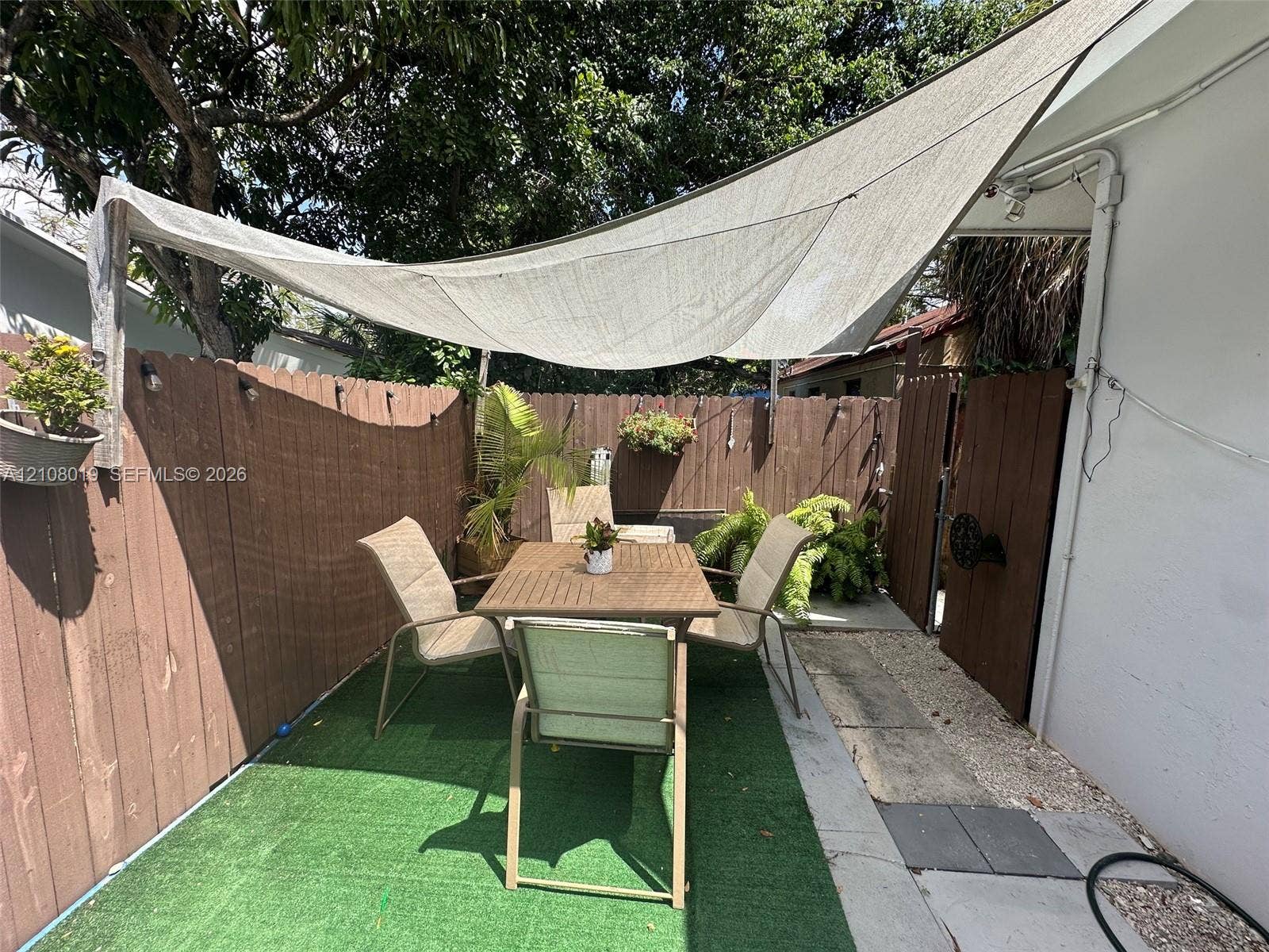 1105 NE 5th Terrace, #1-4, Fort Lauderdale, Fort Lauderdale, FL 33304 Enclosed patio area featuring a vertical wood fence, artificial turf surfacing, and an overhead tensioned sun shade sail
