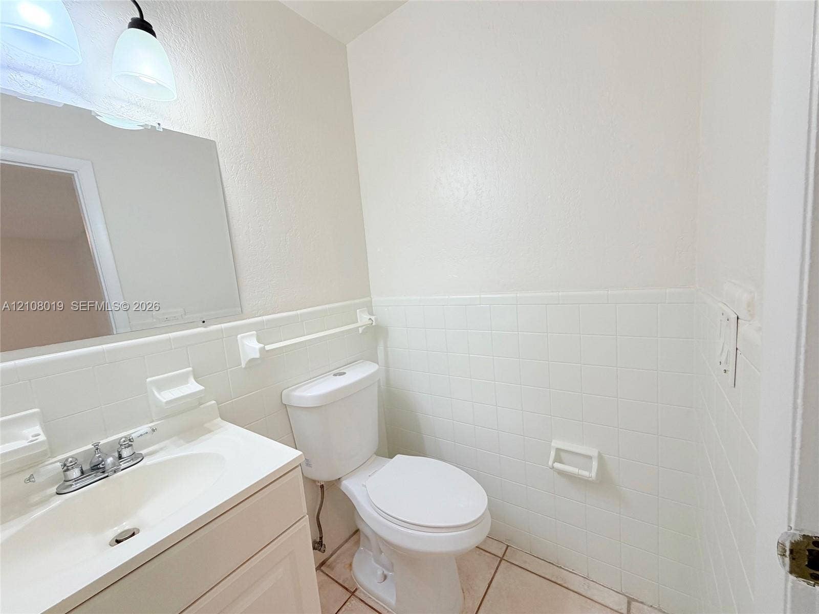 1105 NE 5th Terrace, #1-4, Fort Lauderdale, Fort Lauderdale, FL 33304 Bathroom featuring a vanity with an integrated sink, polished chrome widespread faucet, wall-mounted mirror, ceramic tile wainscoting, and ceramic floor tiling