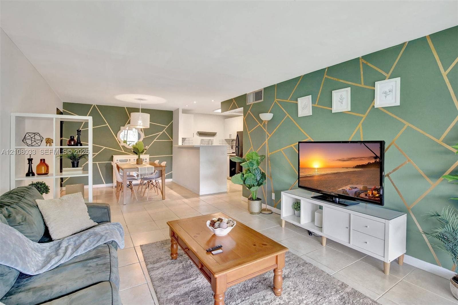 5821 Washington Street, #30, Hollywood, Hollywood, FL 33023 Open-concept floor plan featuring large-format ceramic tile flooring, accent walls with geometric gold detailing, and a kitchen peninsula