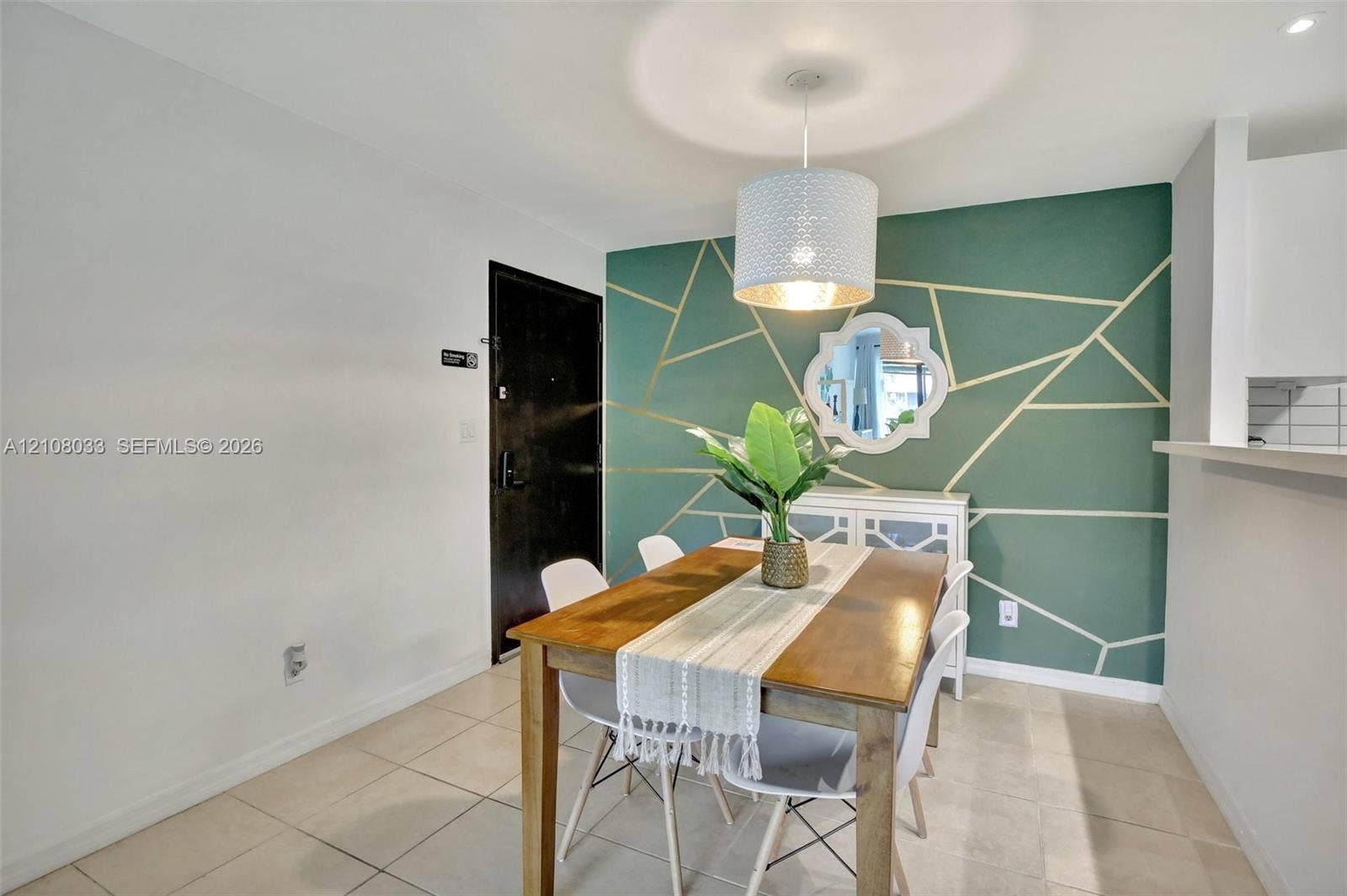 5821 Washington Street, #30, Hollywood, Hollywood, FL 33023 Geometric accent wall with gold-toned detailing, neutral tile flooring, and suspended drum pendant lighting