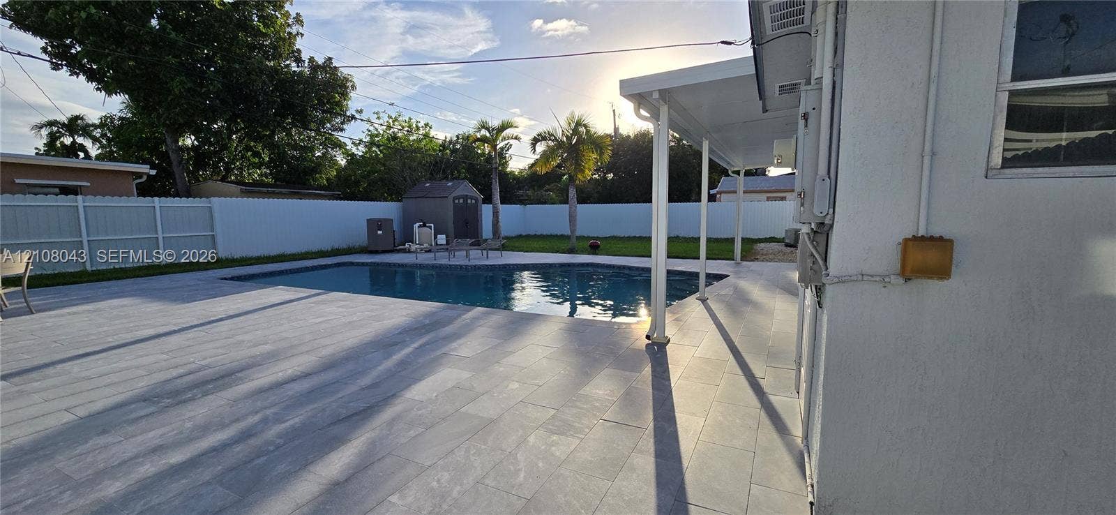 7176 SW 12th Street, #7176, Miami, Miami, FL 33144 Backyard featuring a concrete-tiled patio, in-ground swimming pool, covered lanai, and white vinyl privacy fencing