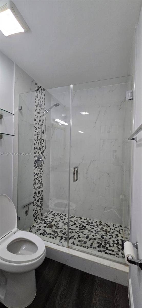 7176 SW 12th Street, #7176, Miami, Miami, FL 33144 Walk-in shower featuring a frameless glass door, stone-finish mosaic floor tile, accent tile wall detail, and chrome shower fixtures
