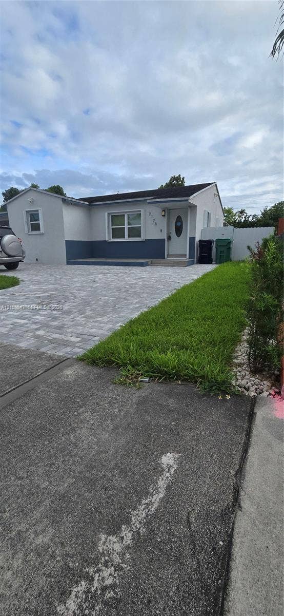 7176 SW 12th Street, #7176, Miami, Miami, FL 33144 Single-story exterior featuring a two-tone smooth stucco finish, paver driveway, front porch, and horizontal sliding windows