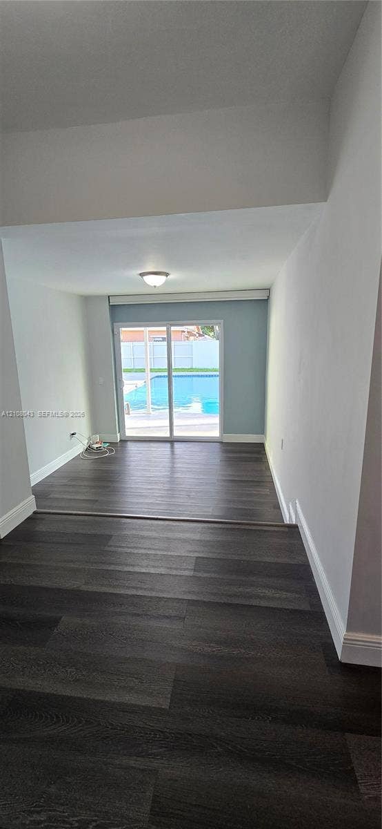 7176 SW 12th Street, #7176, Miami, Miami, FL 33144 Interior featuring wood-finish flooring, recessed lighting, and sliding glass doors revealing an outdoor swimming pool