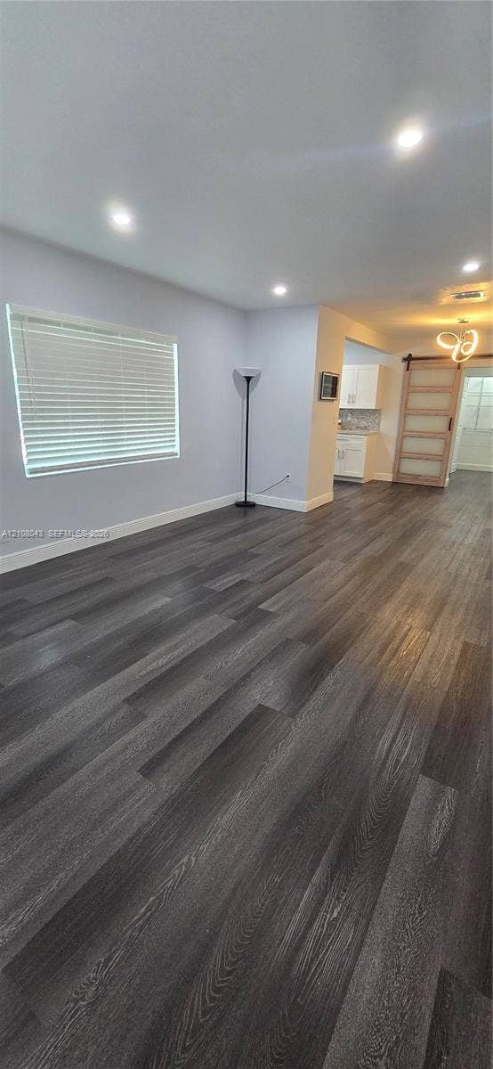 7176 SW 12th Street, #7176, Miami, Miami, FL 33144 Open-concept room featuring wood-finish flooring, recessed lighting, horizontal window blinds, and a sliding barn-style door