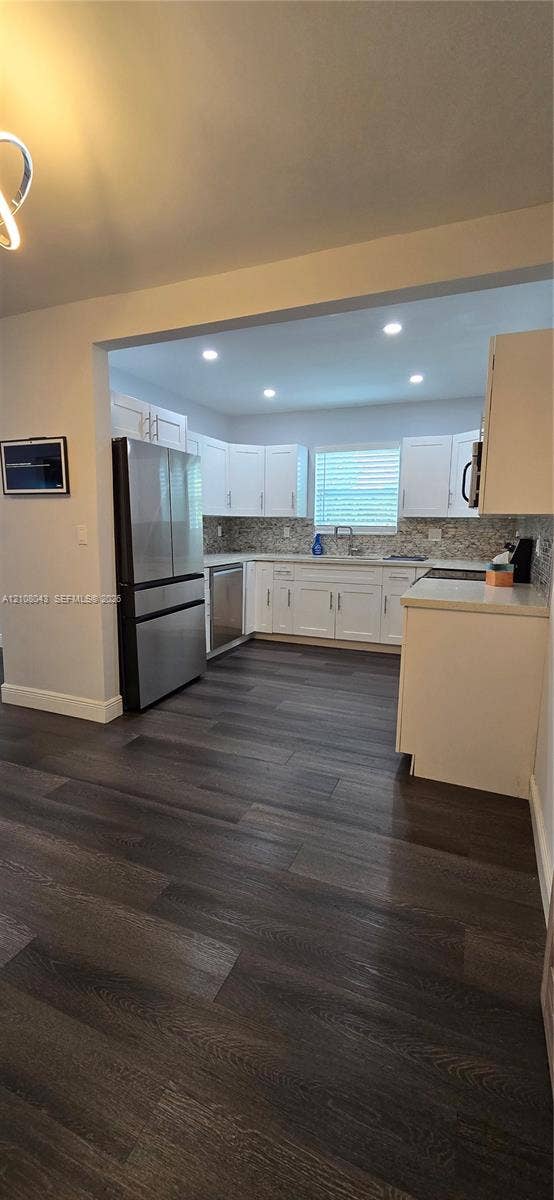 7176 SW 12th Street, #7176, Miami, Miami, FL 33144 Kitchen featuring white shaker-style cabinetry, stainless steel appliances, patterned tile backsplash, recessed lighting, and wood-finish flooring