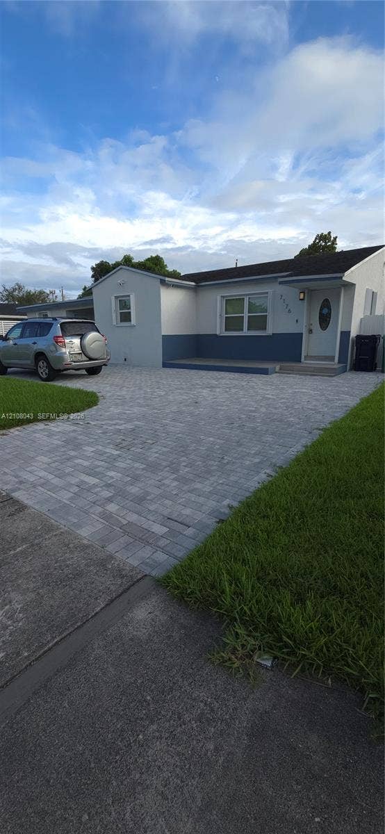 7176 SW 12th Street, #7176, Miami, Miami, FL 33144 Single-story exterior featuring a two-tone smooth stucco finish, paver driveway, covered front entryway, and asphalt shingle roofing