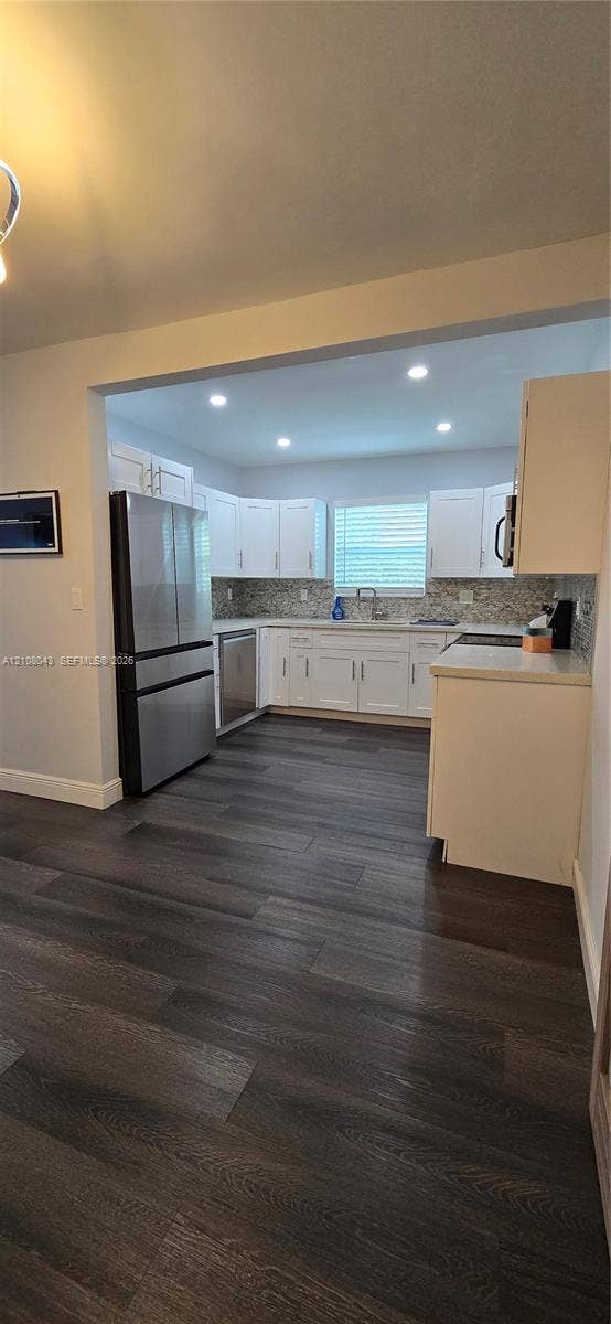 7176 SW 12th Street, #7176, Miami, Miami, FL 33144 Kitchen featuring white shaker-style cabinetry, stainless steel appliances, recessed ceiling lighting, wood-finish flooring, and a patterned tile backsplash