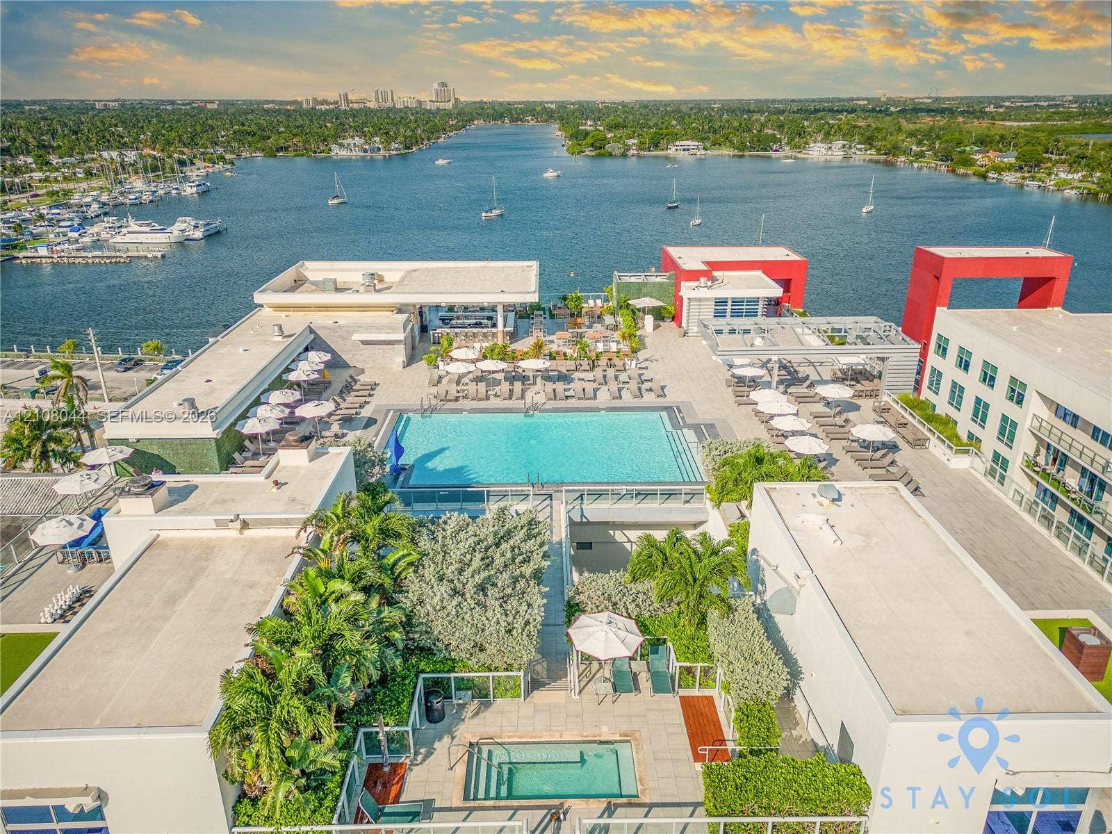 Rooftop deck featuring a swimming pool, spa, built-in bar, and water-front placement