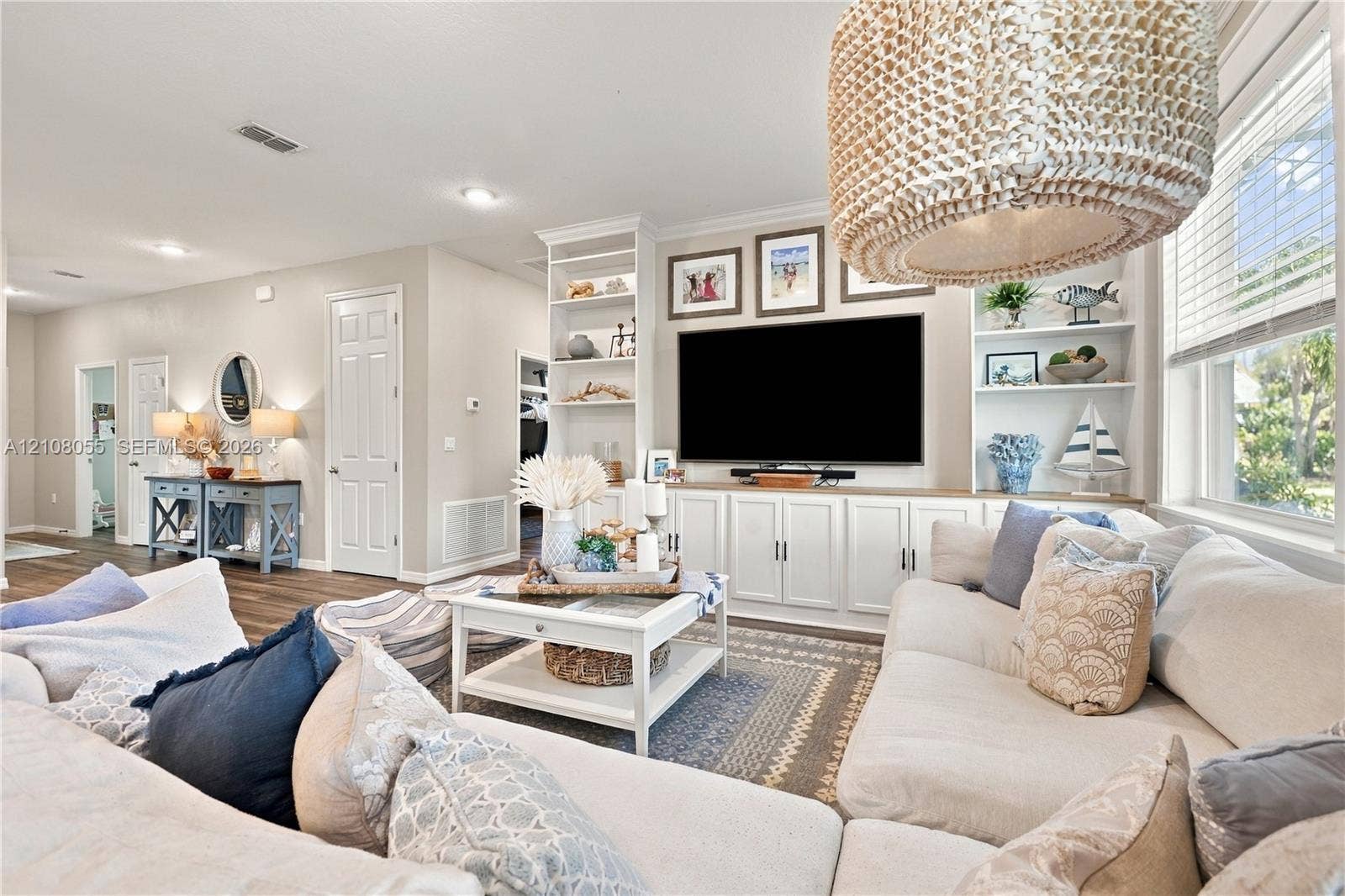 557 SW Lacroix Avenue, Port St Lucie, FL 34953 Custom floor-to-ceiling built-in cabinetry featuring open shelving and base storage, recessed lighting, and a textured woven drum pendant light