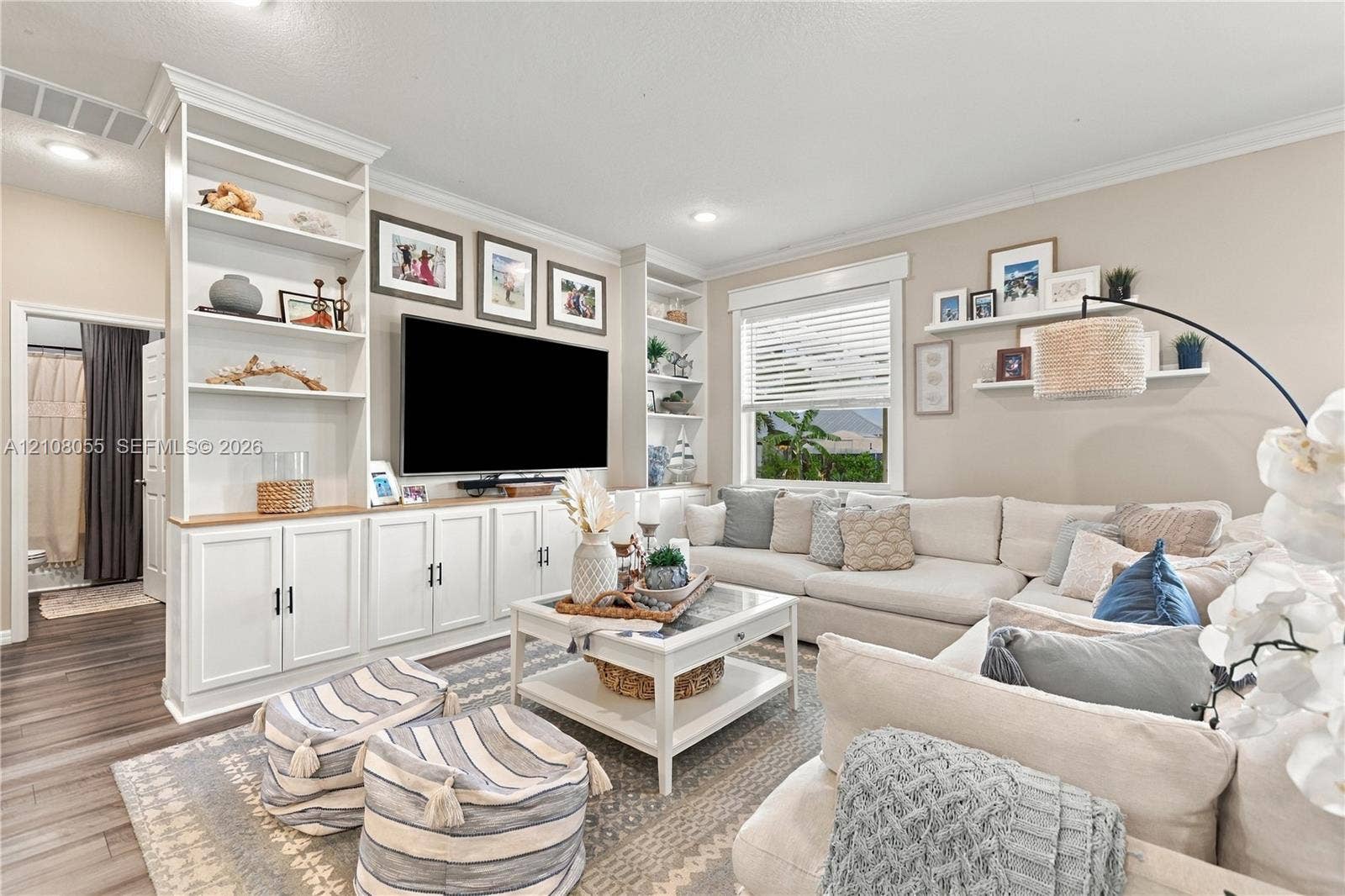 557 SW Lacroix Avenue, Port St Lucie, FL 34953 Built-in floor-to-ceiling white cabinetry, wood-finish flooring, recessed lighting, and white floating wall shelves