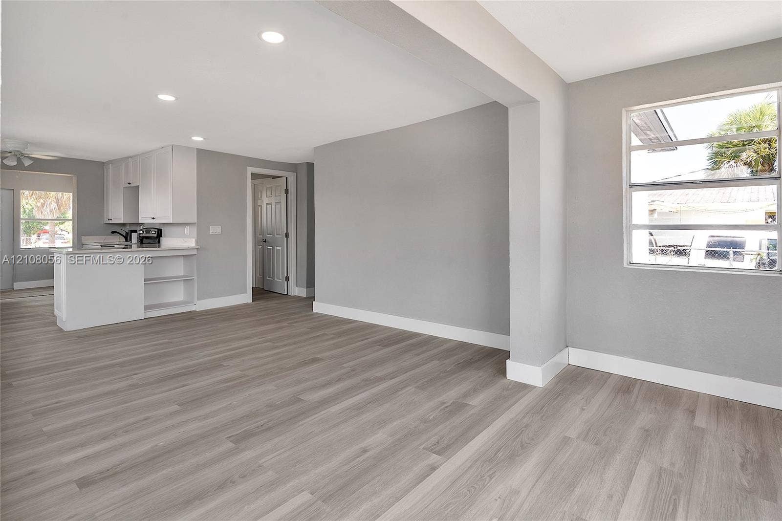 1444 W 28th Street, Riviera Beach, FL 33404 Neutral-toned interior featuring wood-finish flooring, recessed lighting, and white cabinetry with a built-in island