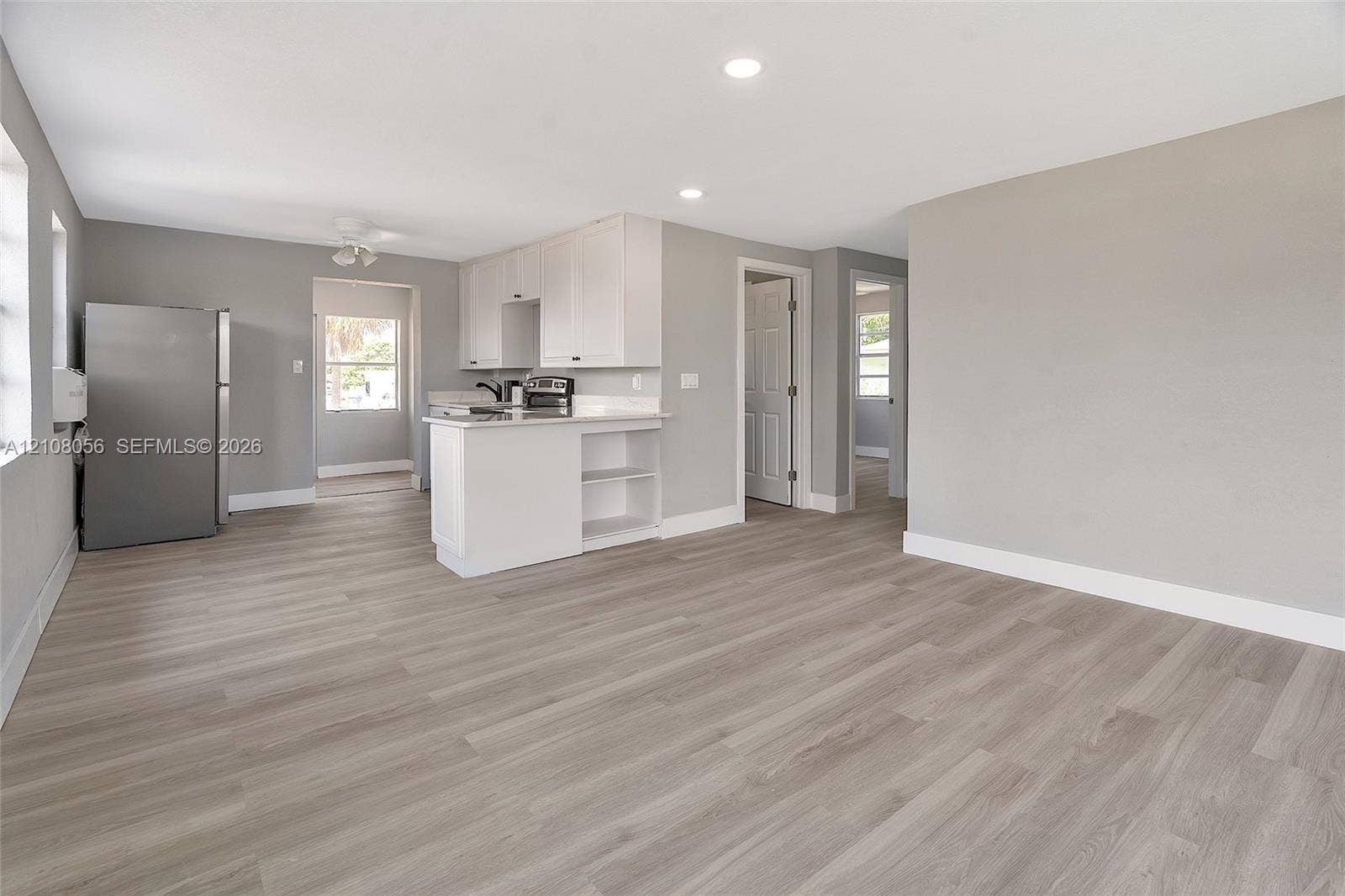 1444 W 28th Street, Riviera Beach, FL 33404 Kitchen featuring white cabinetry, wood-finish flooring, recessed lighting, and a peninsula counter