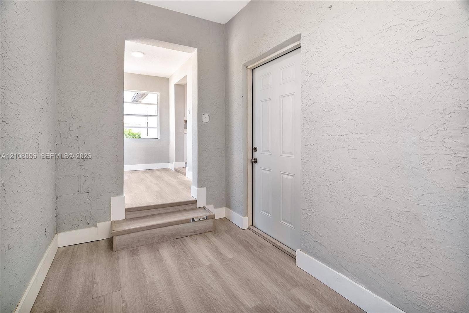 1444 W 28th Street, Riviera Beach, FL 33404 Interior space featuring wood-finish flooring, a multi-panel door, and textured walls