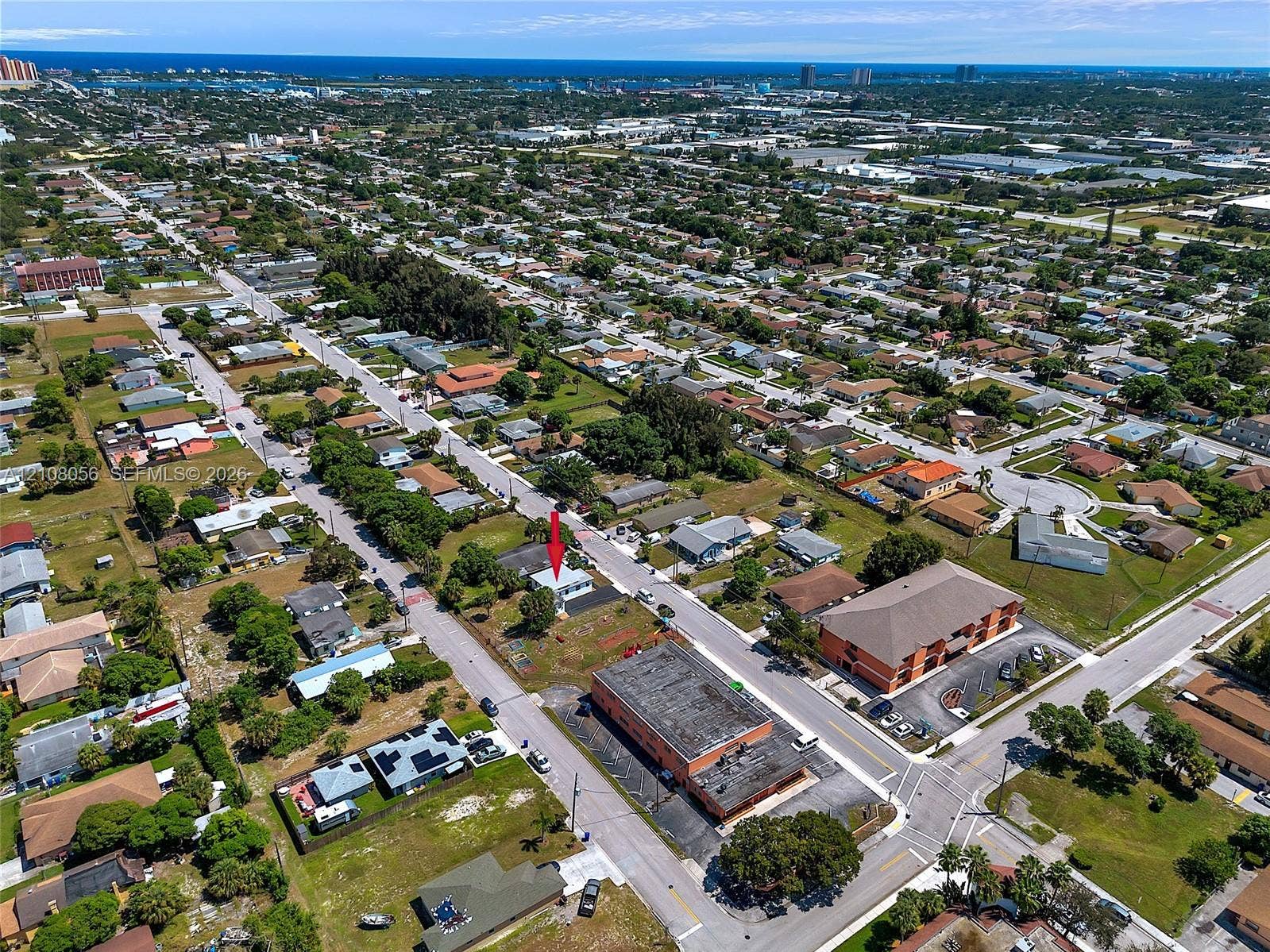 1444 W 28th Street, Riviera Beach, FL 33404 Aerial perspective of a detached property featuring a pitched roof, front-facing exterior entrance, and onsite driveway, situated within a coastal region