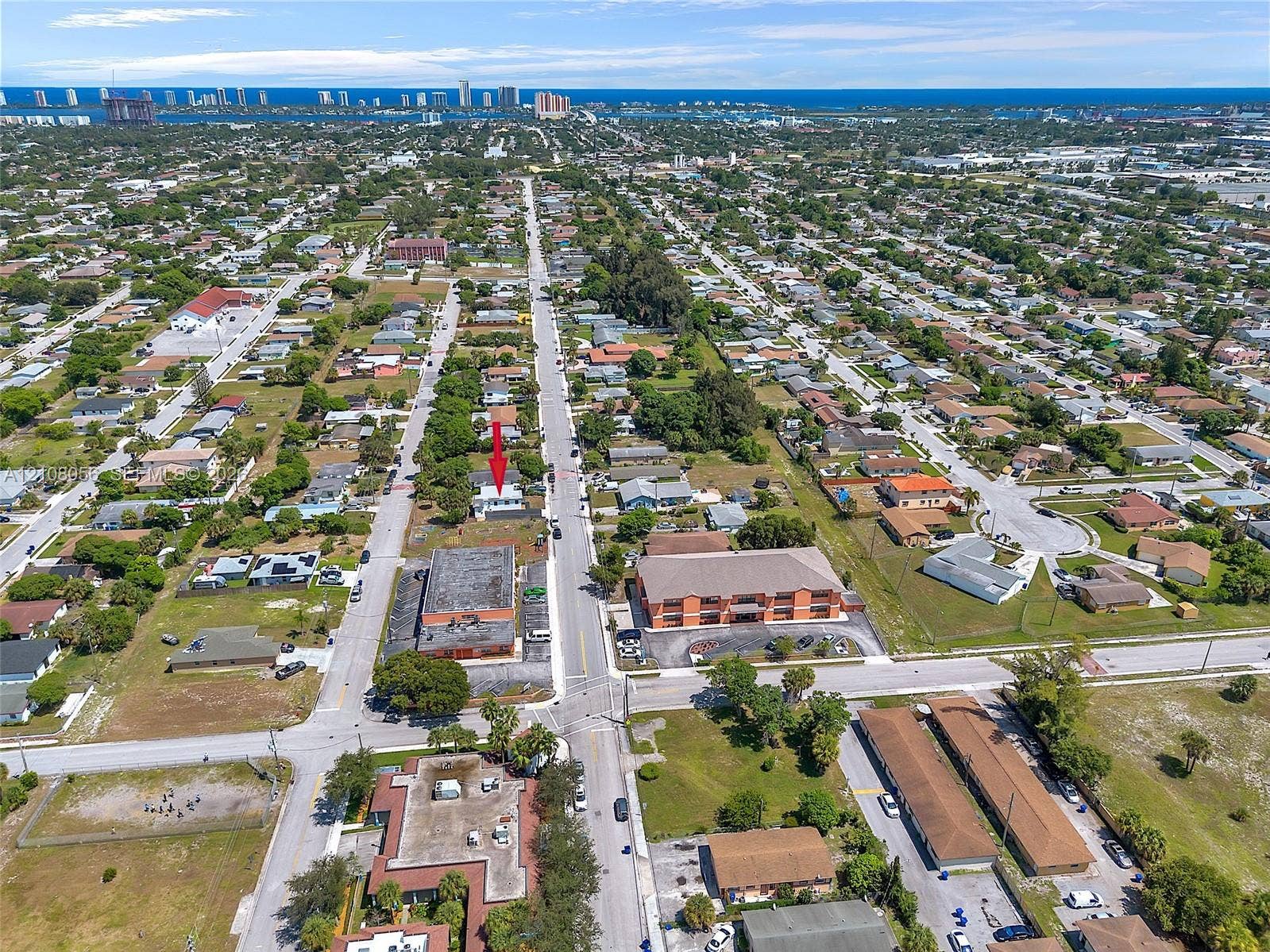 1444 W 28th Street, Riviera Beach, FL 33404 Aerial view of residential property situated in a coastal vicinity featuring paved street access and proximity to regional infrastructure