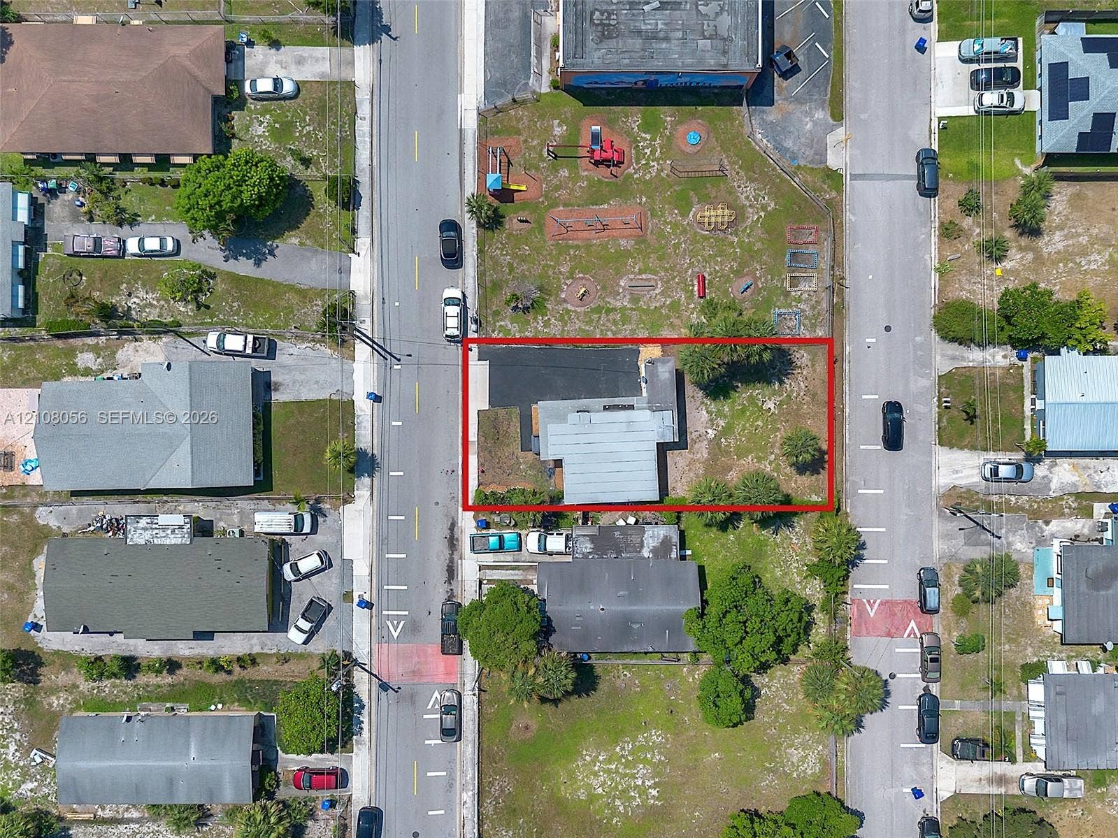 1444 W 28th Street, Riviera Beach, FL 33404 Aerial view of a corner lot featuring an asphalt driveway and perimeter landscaping