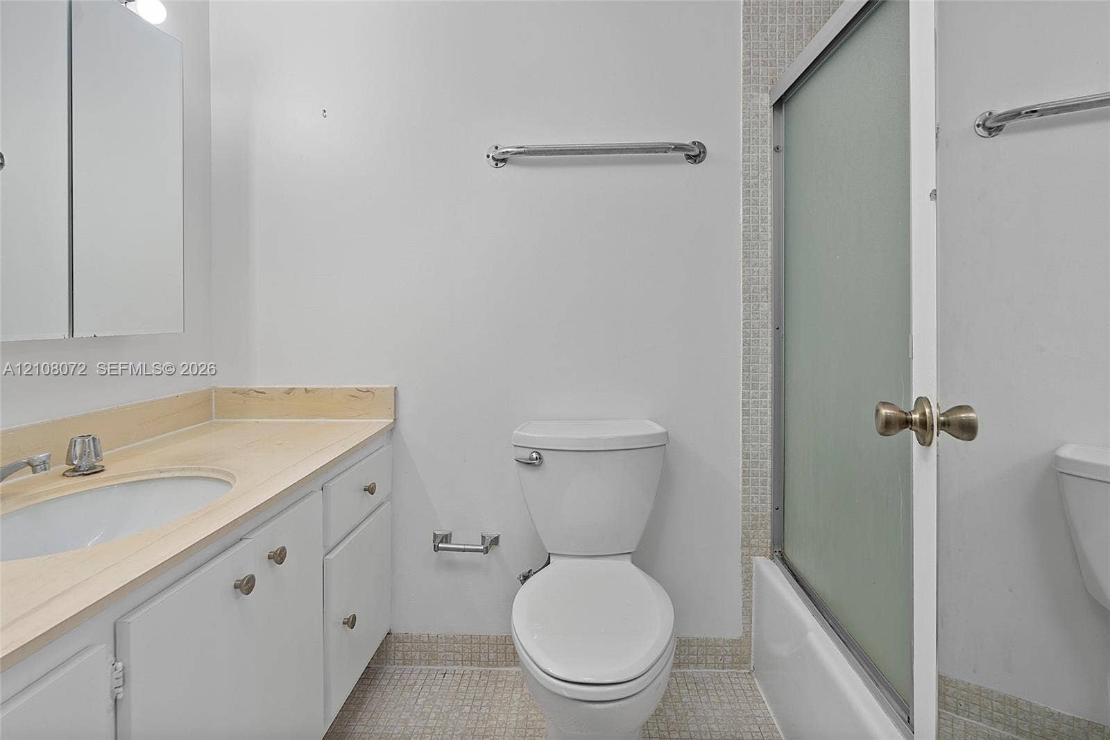 Bathroom featuring a white vanity cabinet, solid-surface countertop with an integrated sink, floor-to-ceiling mosaic tile shower surround, and sliding glass shower door